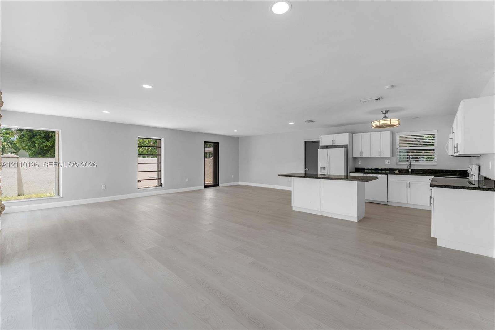 4400 SW 89th Avenue, #4400, Miami, Miami, FL 33165 Open-concept kitchen featuring white shaker-style cabinetry, dark stone countertops, a center island, recessed lighting, and light-tone wood-finish flooring throughout