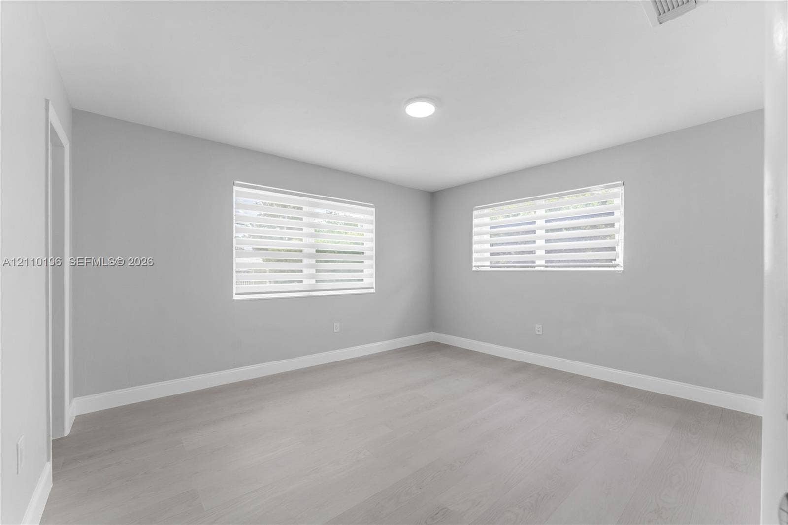 4400 SW 89th Avenue, #4400, Miami, Miami, FL 33165 Neutral-toned interior space featuring wood-finish flooring, recessed lighting, and dual-pane windows with integrated light-filtering shades