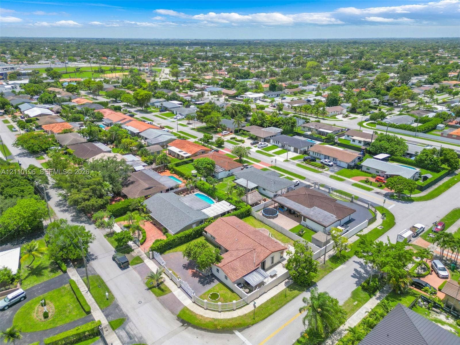 4400 SW 89th Avenue, #4400, Miami, Miami, FL 33165 Aerial perspective of a corner lot property featuring a clay tile roof, concrete paved driveway, perimeter wall, and manicured landscaping