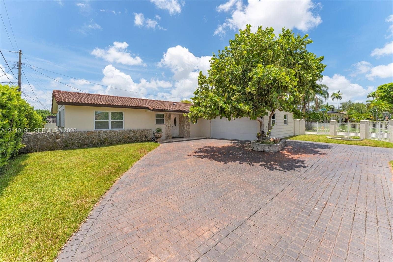 4400 SW 89th Avenue, #4400, Miami, Miami, FL 33165 Single-story residence featuring a tile roof, natural stone exterior accents, a paved driveway, and a raised stone planter