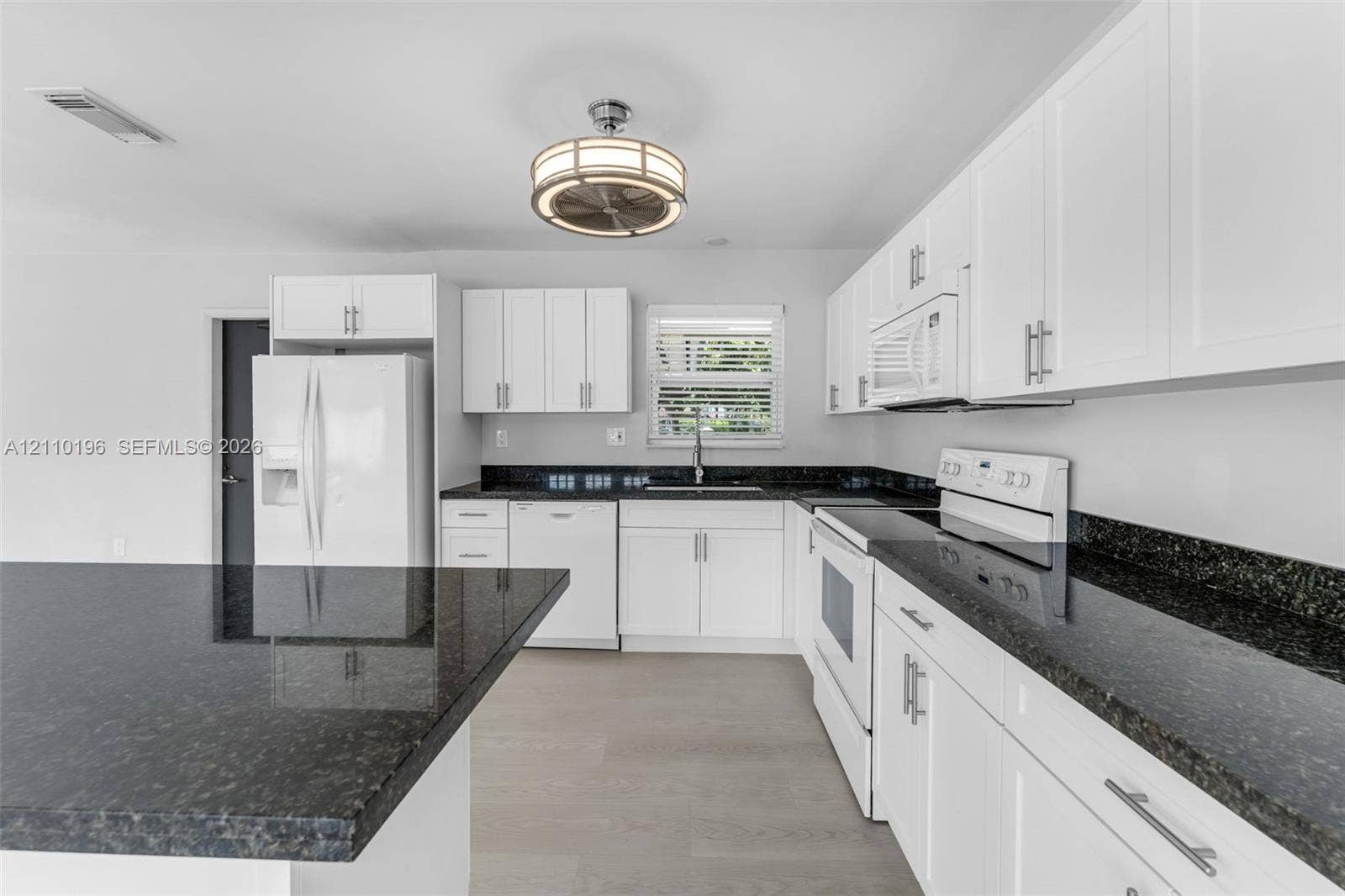 4400 SW 89th Avenue, #4400, Miami, Miami, FL 33165 Kitchen featuring white shaker-style cabinetry, dark stone countertops, an integrated island, wood-finish flooring, and a drum-style ceiling light fixture
