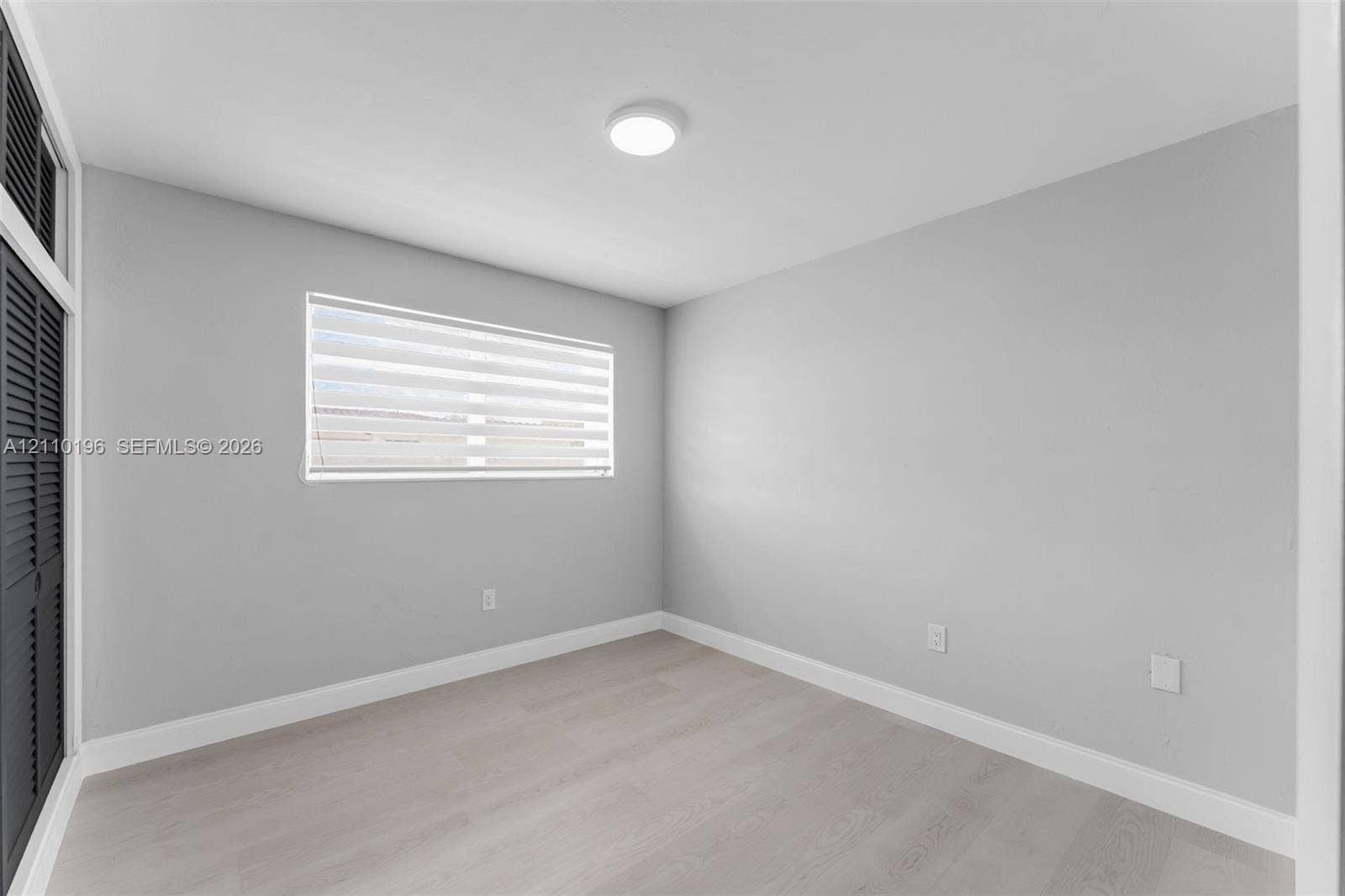 4400 SW 89th Avenue, #4400, Miami, Miami, FL 33165 Room featuring wood-finish flooring, neutral wall paint, a flush-mount ceiling light, and louvered-style closet doors