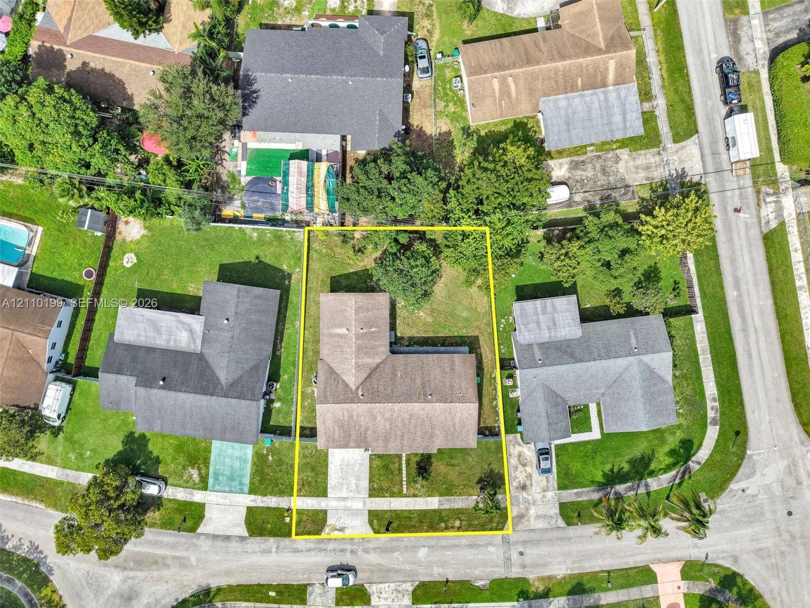 10741 SW 165th Street, Miami, FL 33157 Aerial view of residential property featuring a pitched-roof structure, concrete driveway, and established lawn with mature perimeter trees