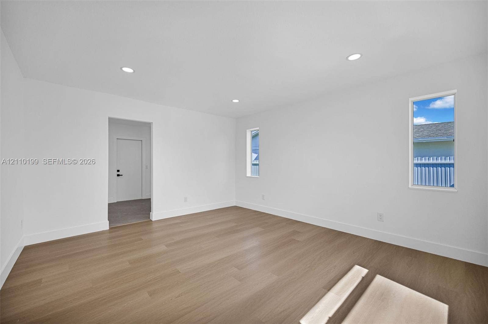 10741 SW 165th Street, Miami, FL 33157 Neutral interior space featuring wood-finish flooring, recessed lighting, and dual vertical windows