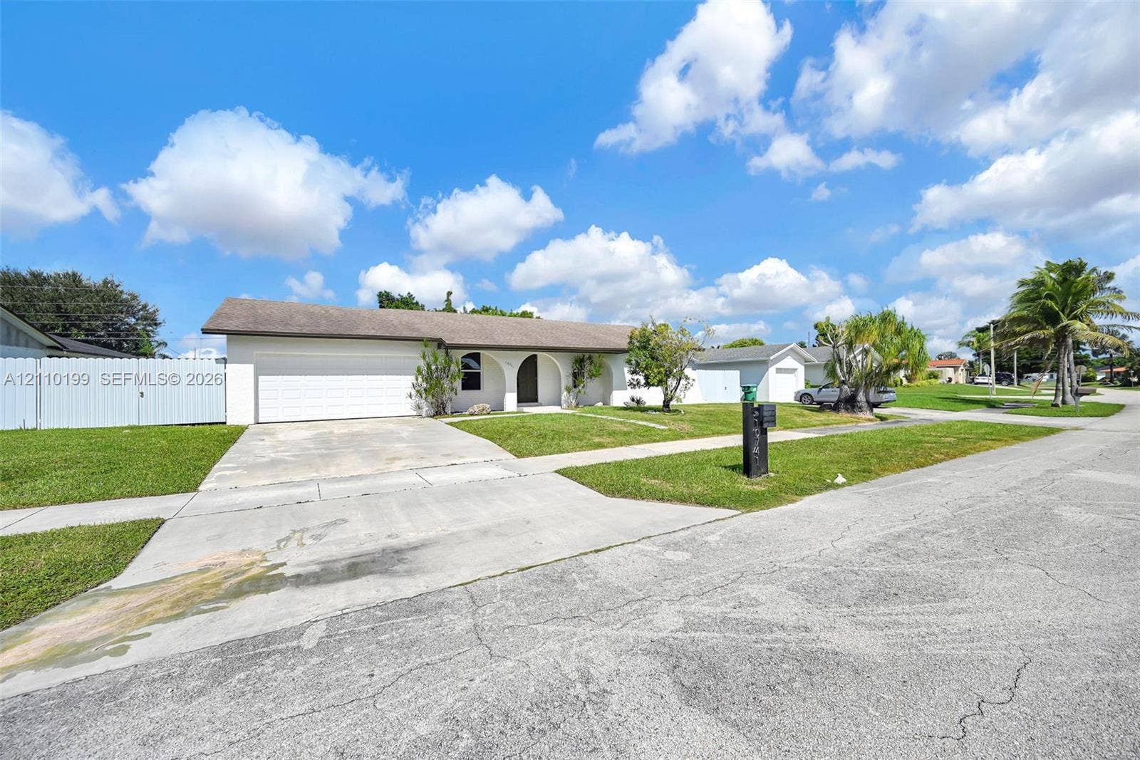 10741 SW 165th Street, Miami, FL 33157 Single-story residence featuring a stucco exterior, arched covered entryway, two-car garage, and concrete driveway