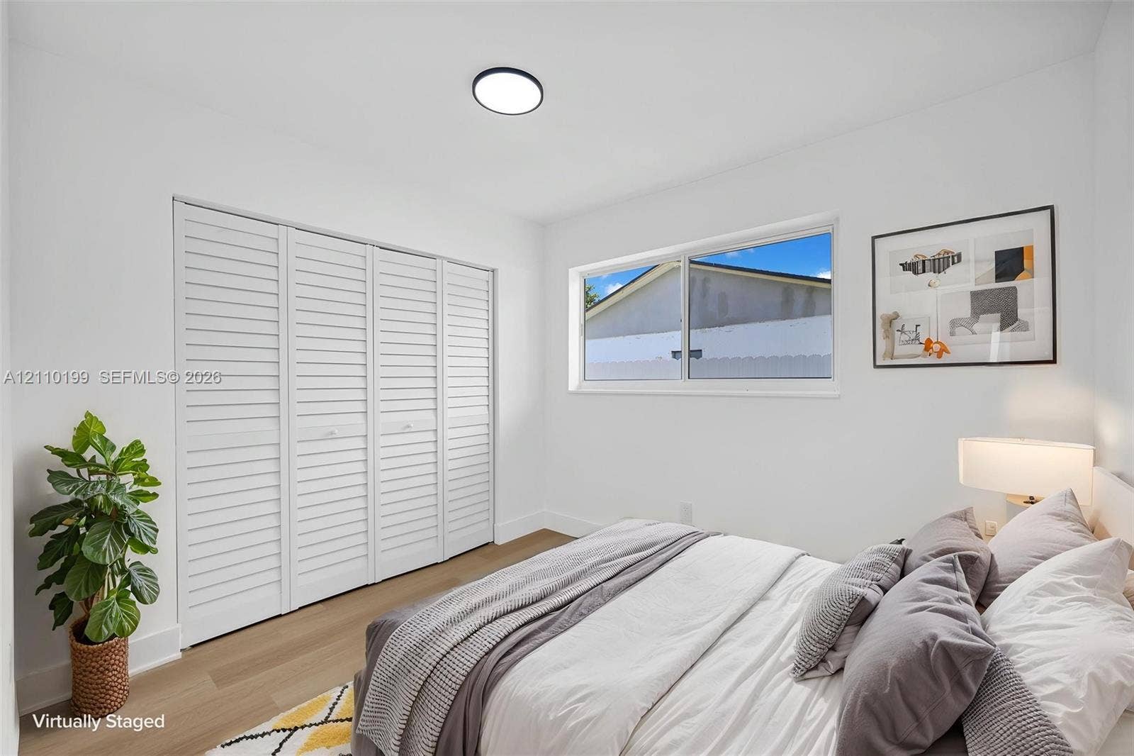 10741 SW 165th Street, Miami, FL 33157 Room featuring wood-finish flooring, white walls, louvered closet doors, and a ceiling-mounted light fixture