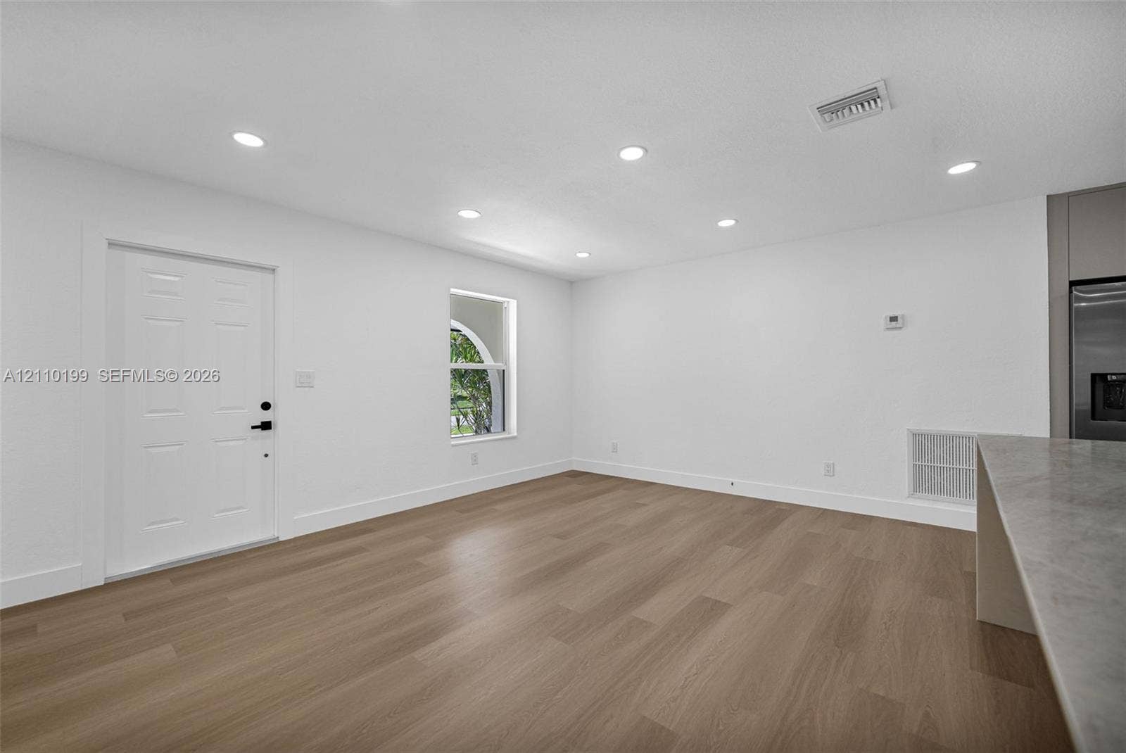 10741 SW 165th Street, Miami, FL 33157 Wood-finish flooring, recessed lighting, arched window, and solid-core paneled entry door