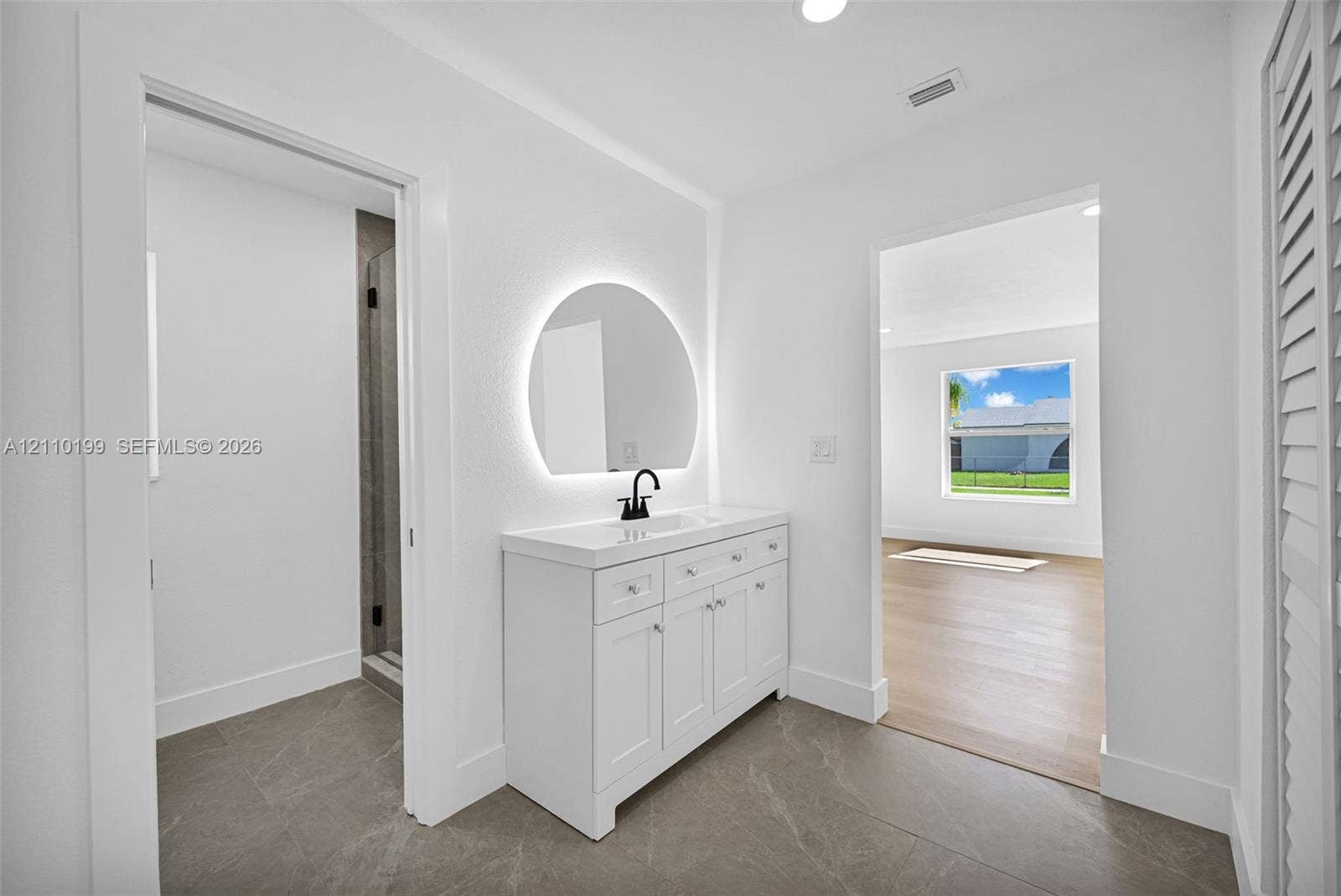 10741 SW 165th Street, Miami, FL 33157 White vanity featuring a rectangular integrated sink, matte black faucet, and stone-finish tile flooring