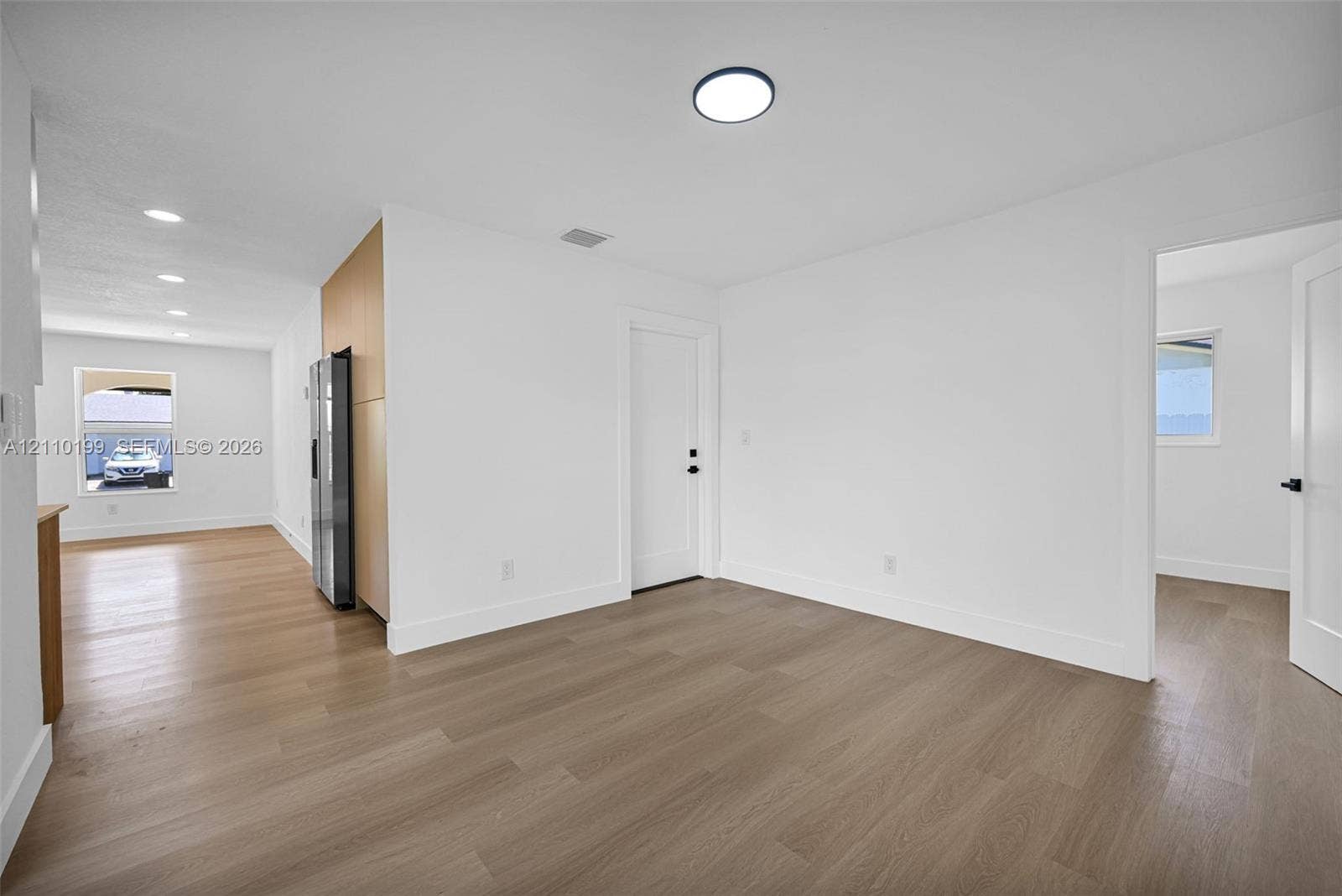 10741 SW 165th Street, Miami, FL 33157 Interior space featuring light-toned wood-finish flooring, recessed LED lighting, flat-panel cabinetry, and white shaker-style doors