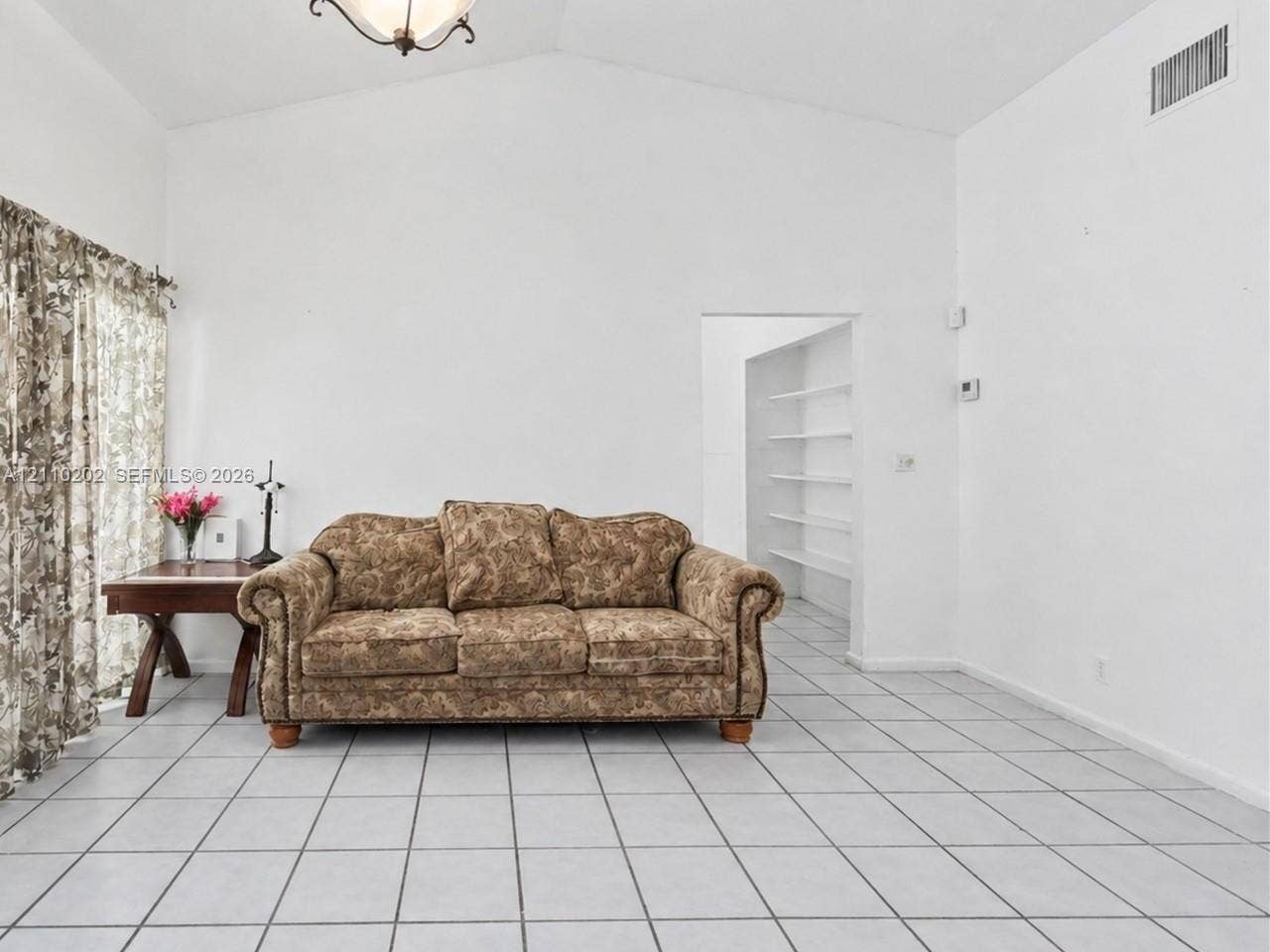 Vaulted ceiling, ceramic tile flooring, and recessed built-in shelving