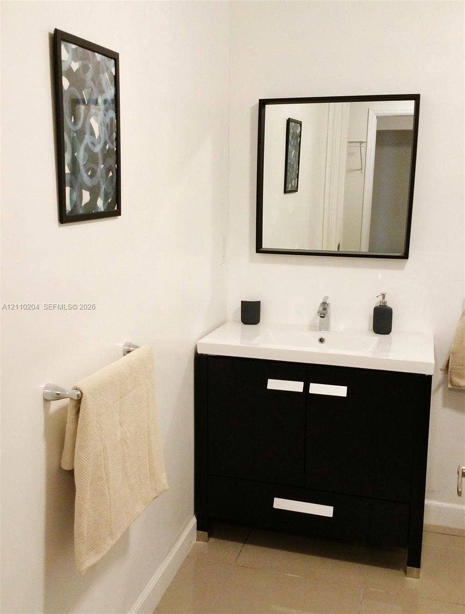 Vanity featuring a dark wood-finish cabinet, integrated white sink basin, chrome-finished hardware, and a matching square mirror