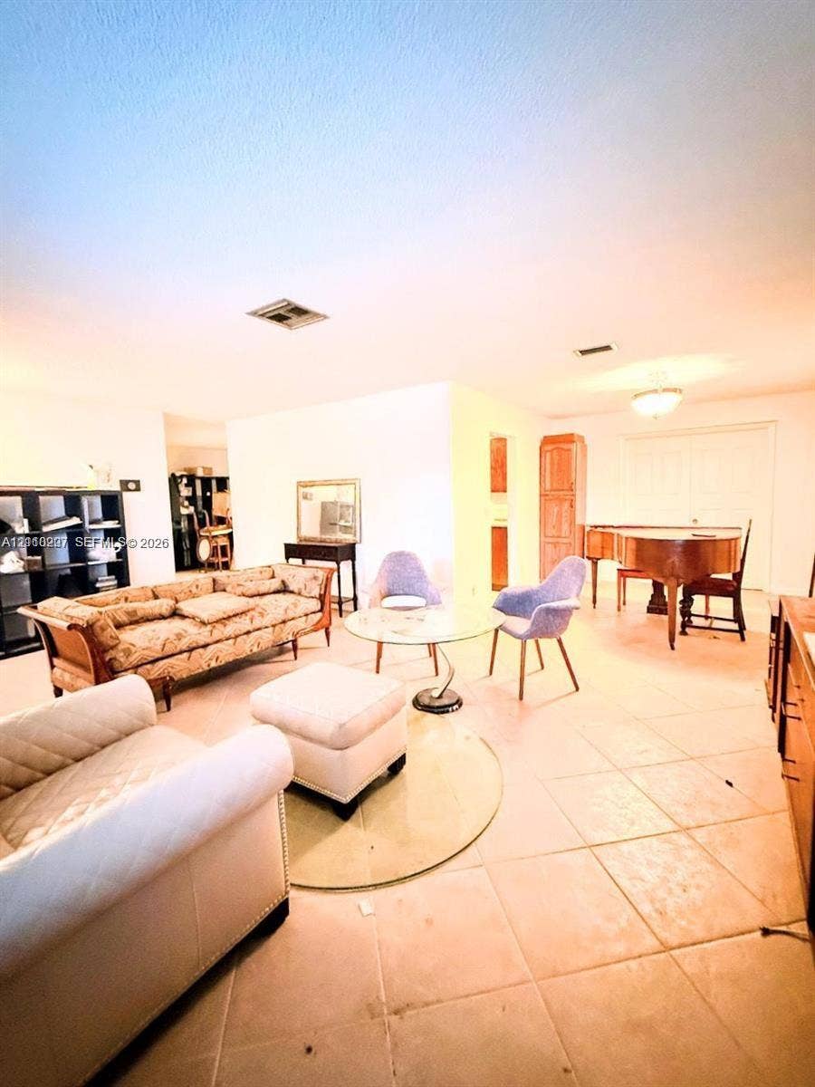 766 NW 24th Avenue, Delray Beach, FL 33445 Open interior space featuring light-toned tile flooring, built-in floor-to-ceiling cabinetry, and recessed lighting