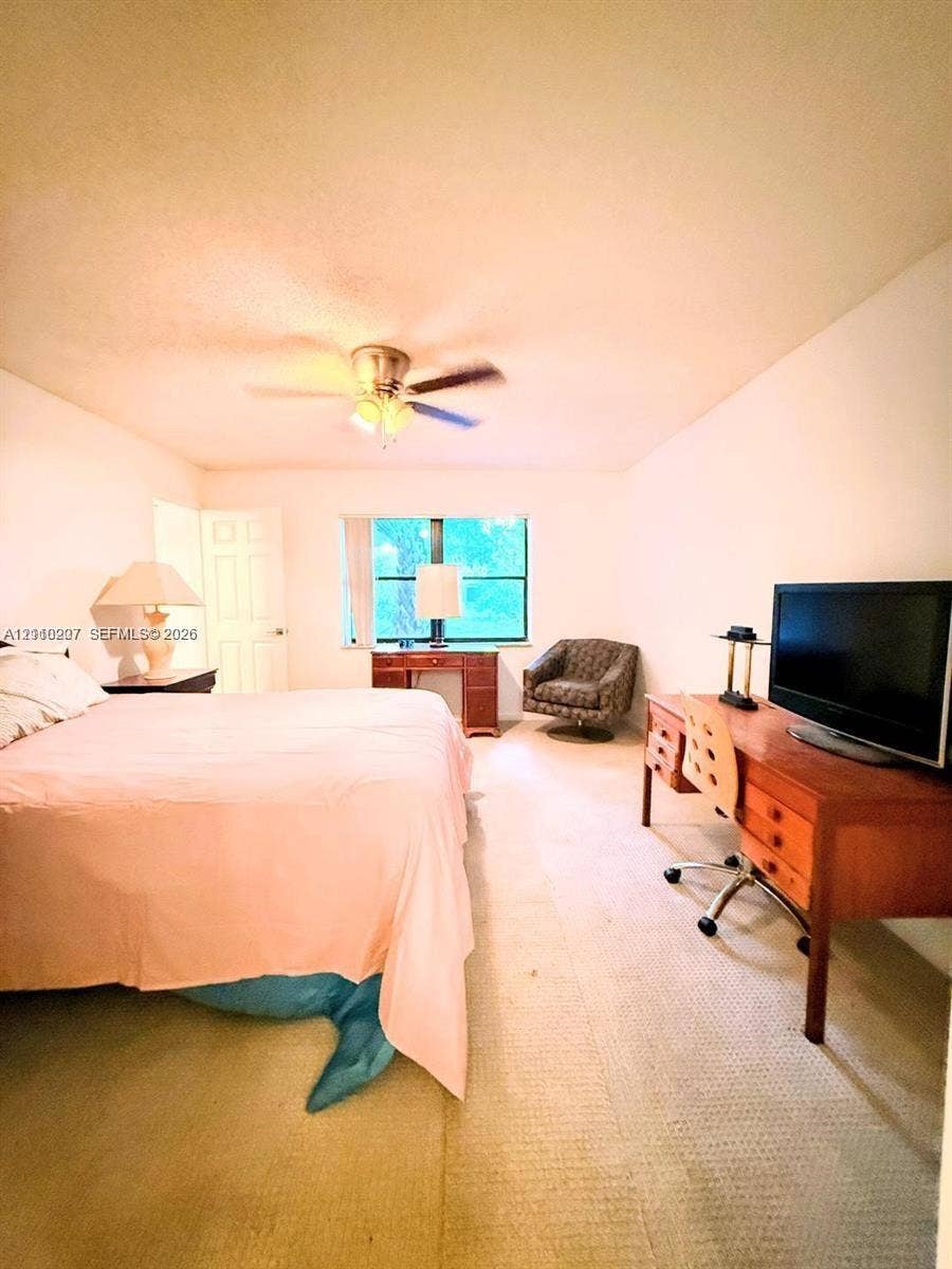 766 NW 24th Avenue, Delray Beach, FL 33445 Room featuring wall-to-wall carpeting, a multi-blade ceiling fan with integrated lighting, and a single-pane window