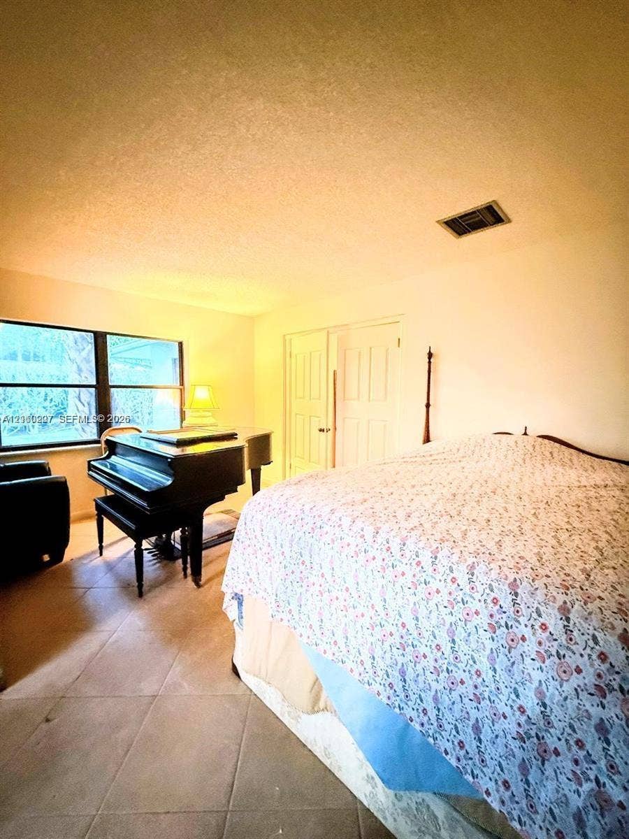 766 NW 24th Avenue, Delray Beach, FL 33445 Room featuring ceramic tile flooring, neutral wall finish, and double-panel closet doors