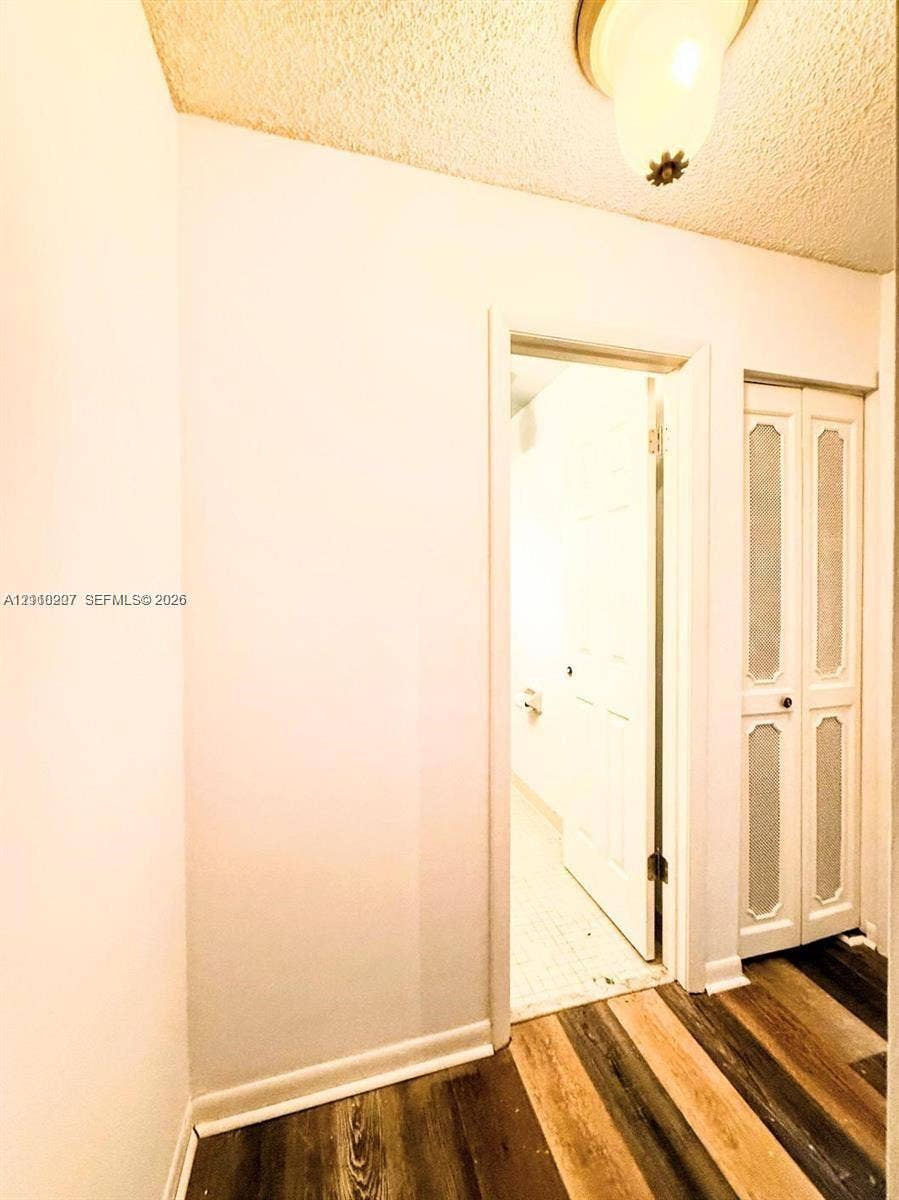 766 NW 24th Avenue, Delray Beach, FL 33445 Wood-finish flooring, bi-fold closet doors with textured glass panel inserts, and ceiling-mounted dome lighting