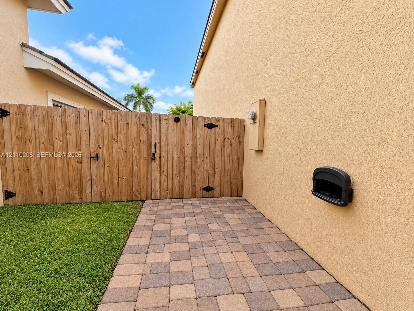 657 SE 30th Terrace, #A, Homestead, Homestead, FL 33033 Side yard featuring a paver patio, wood-finish privacy fencing, and a manicured lawn