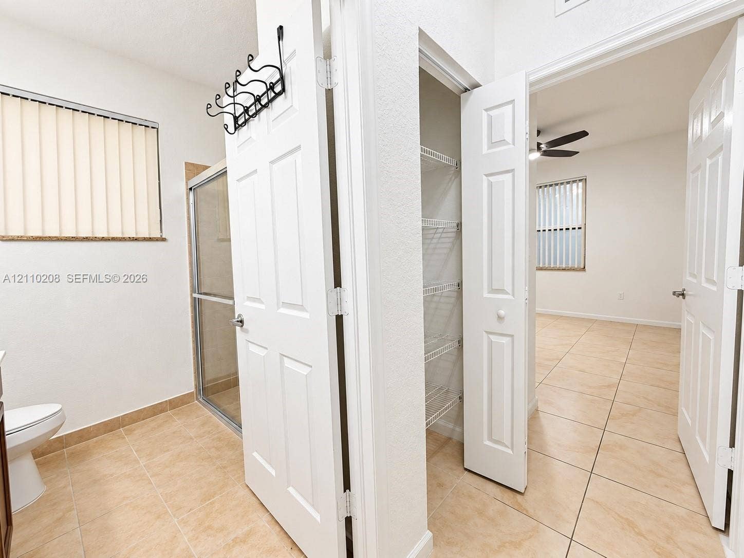 657 SE 30th Terrace, #A, Homestead, Homestead, FL 33033 Neutral-toned tile flooring, built-in wire shelving, glass-enclosed shower, and multi-panel interior doors