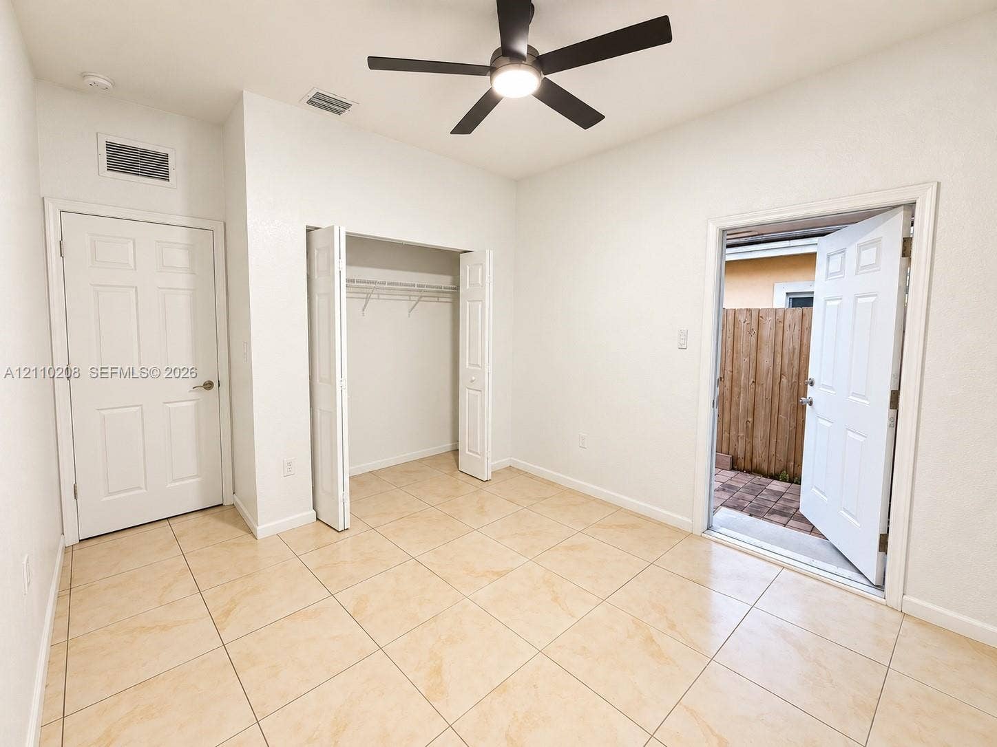 657 SE 30th Terrace, #A, Homestead, Homestead, FL 33033 Neutral-toned tile flooring, built-in closet with folding doors, multi-panel entry door, and a ceiling-mounted light fixture with a fan