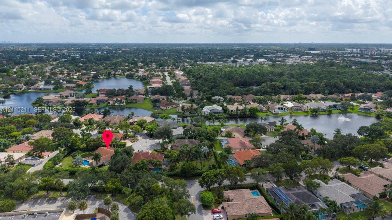 Aerial perspective showcasing a residential property with a tiled roof and a private swimming pool located on a landscaped lot