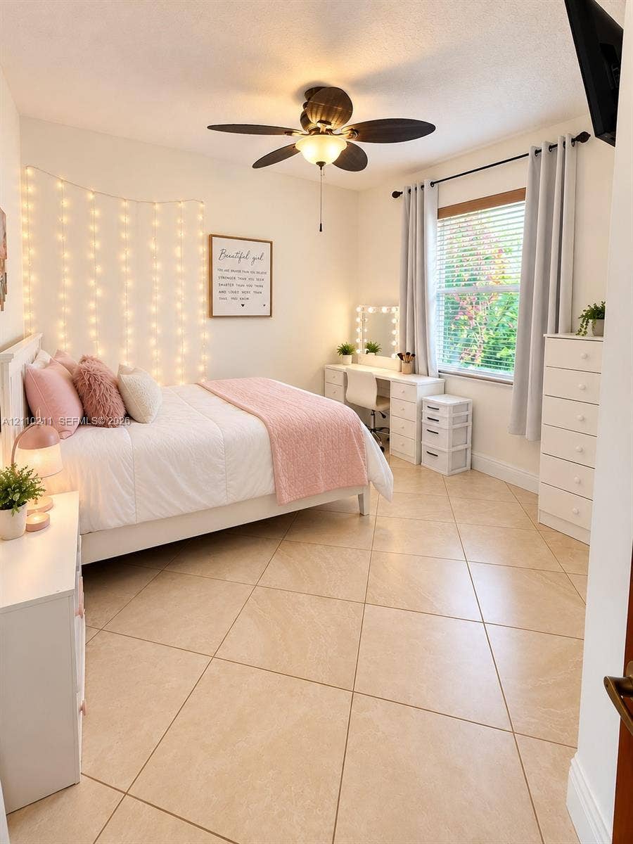 Large-format ceramic tile flooring, ceiling fan with integrated light fixture, window with horizontal blinds, and neutral-toned wall paint