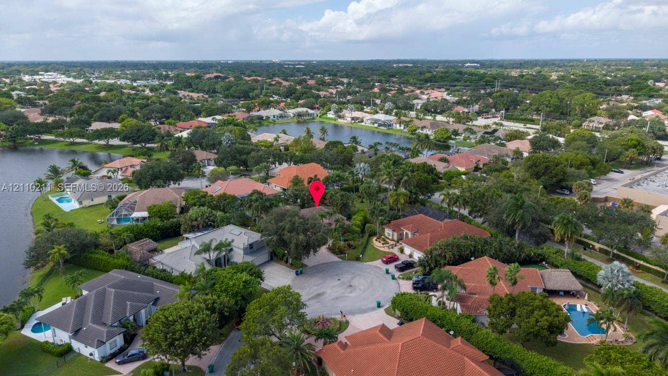 Aerial perspective of a property situated on a cul-de-sac featuring mature tree cover and proximity to regional lakes