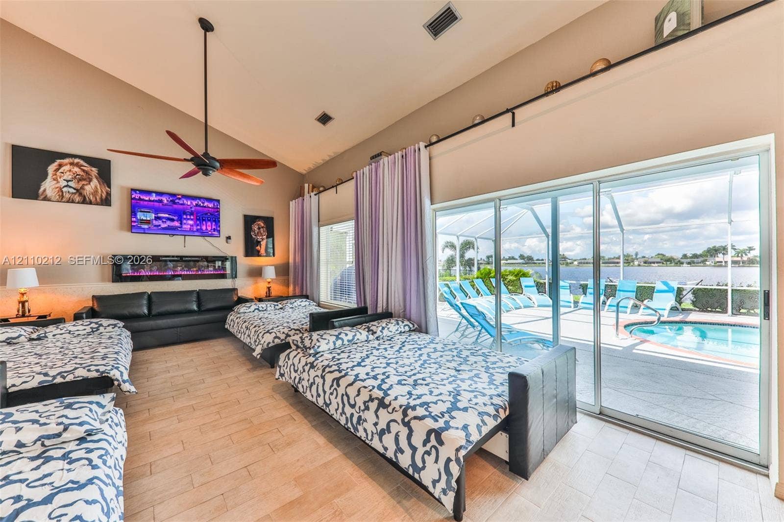 407 SW 37, Cape Coral, FL 33914 Vaulted ceilings, built-in electric wall fireplace, wood-finish tile flooring, ceiling fan, and large sliding glass doors providing outdoor access