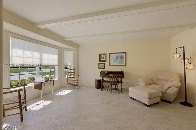 407 SW 37, Cape Coral, FL 33914 Light-filled room featuring neutral tile flooring, exposed ceiling beams, and a prominent bay window with cellular shades