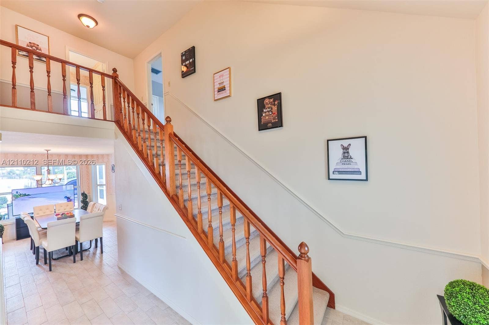407 SW 37, Cape Coral, FL 33914 Staircase featuring wood railings and balusters, vaulted ceilings, and light-toned tile flooring