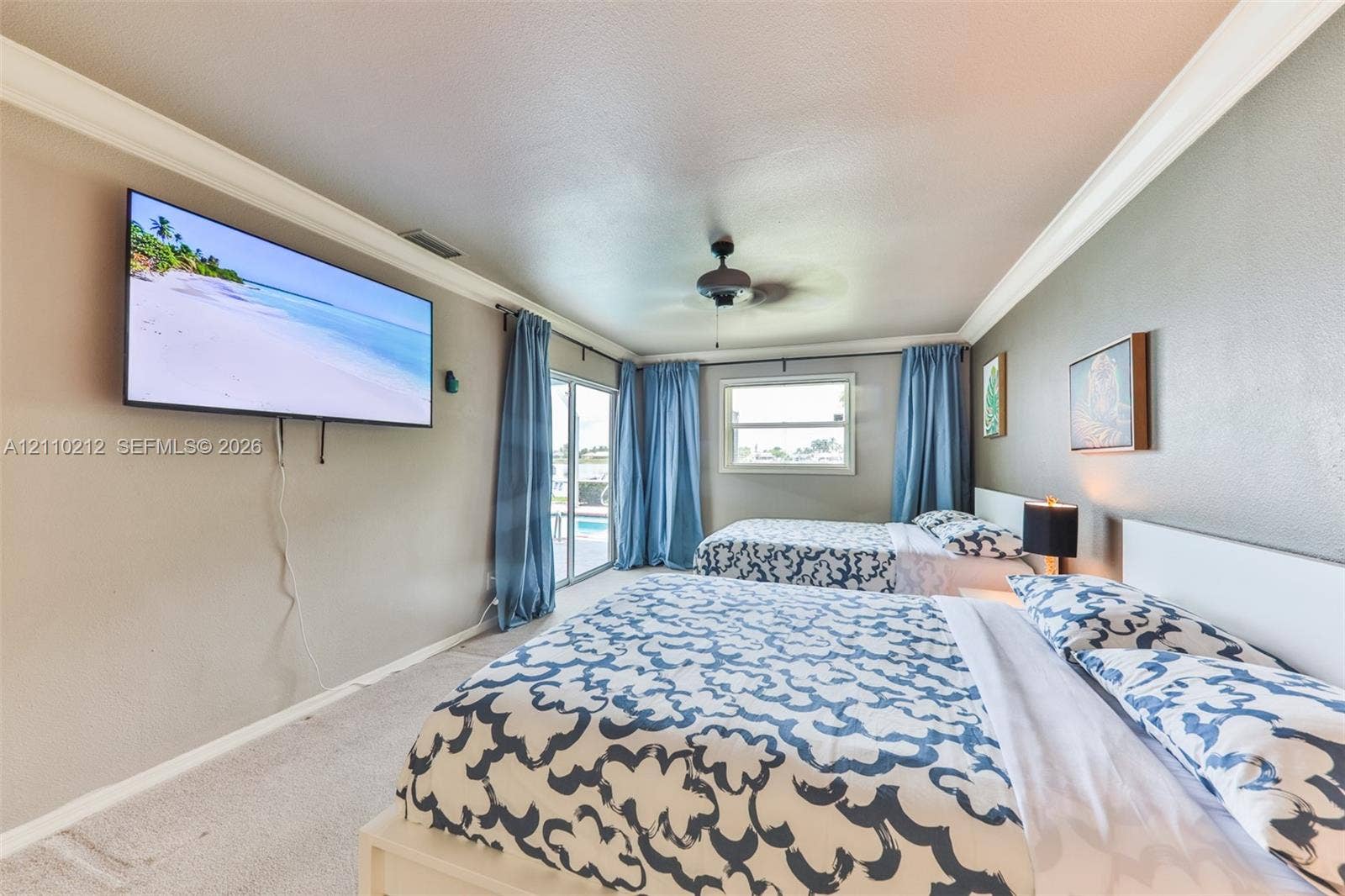407 SW 37, Cape Coral, FL 33914 Neutral-tone interior featuring crown molding, a ceiling fan, and sliding glass doors