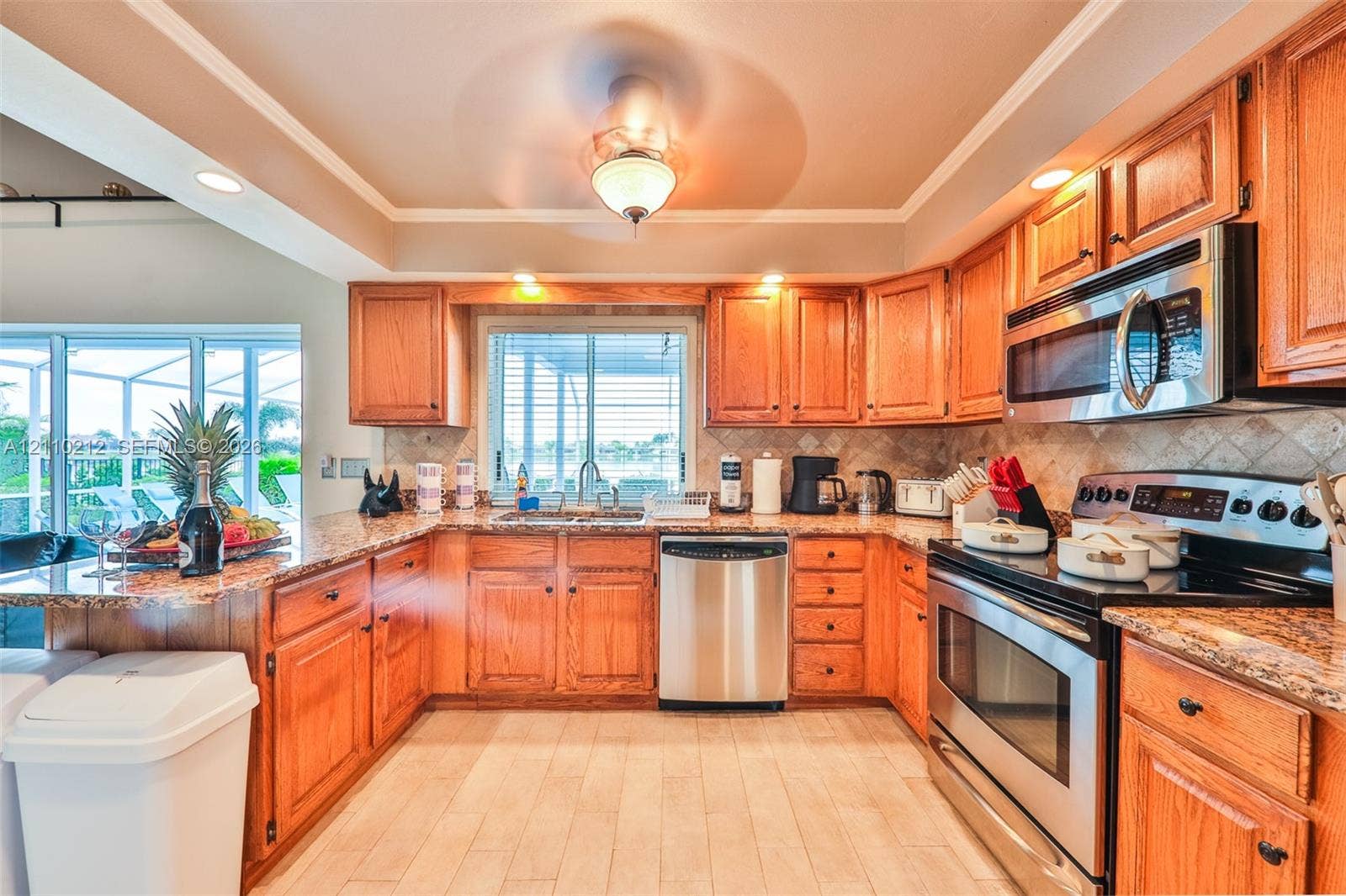 407 SW 37, Cape Coral, FL 33914 Kitchen featuring natural wood cabinetry, stone-finish countertops, stainless steel appliances, a tiled backsplash, and wood-finish flooring
