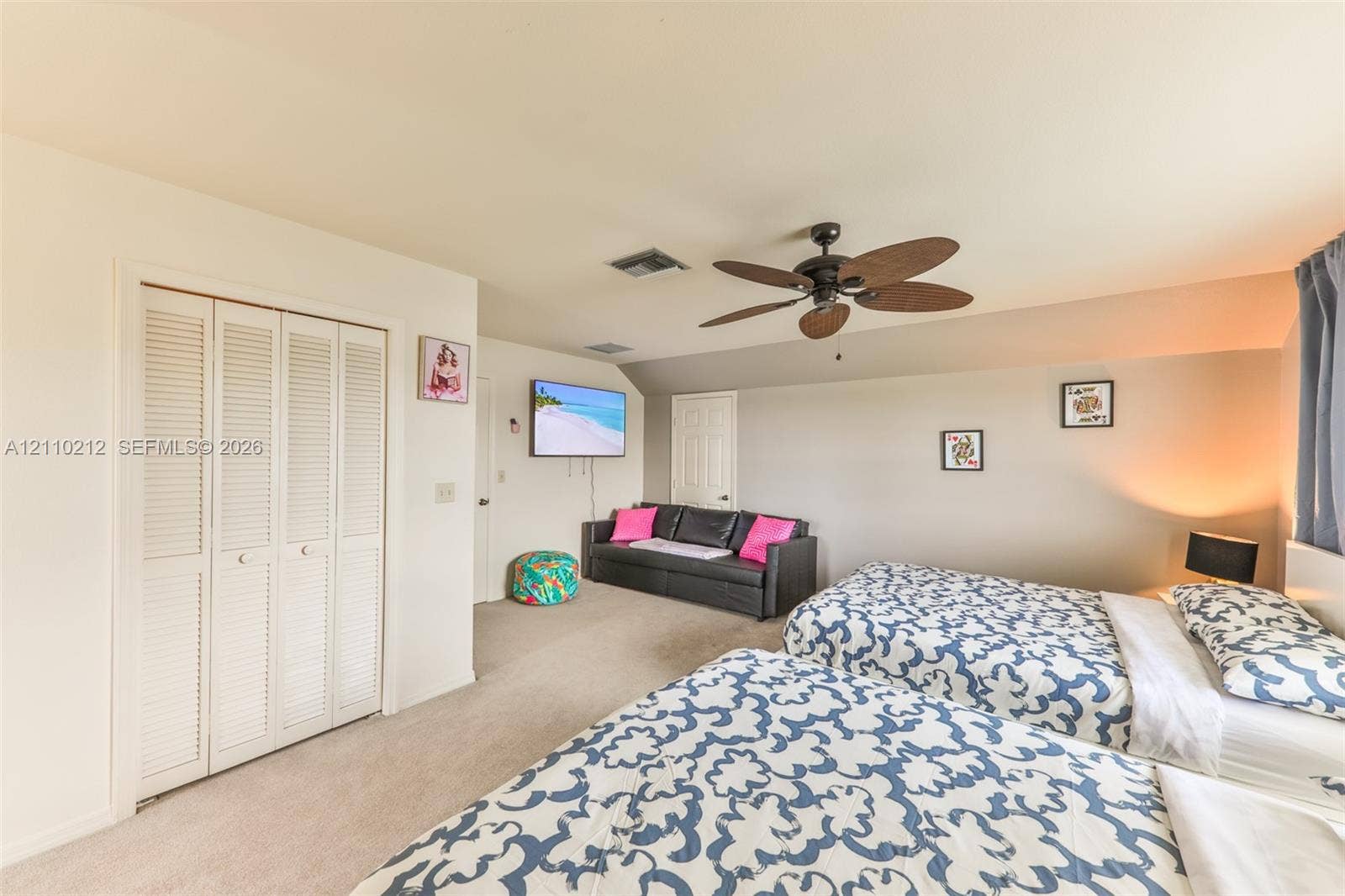 407 SW 37, Cape Coral, FL 33914 Spacious room featuring neutral carpeting, multi-panel louvered closet doors, and a ceiling fan with integrated lighting