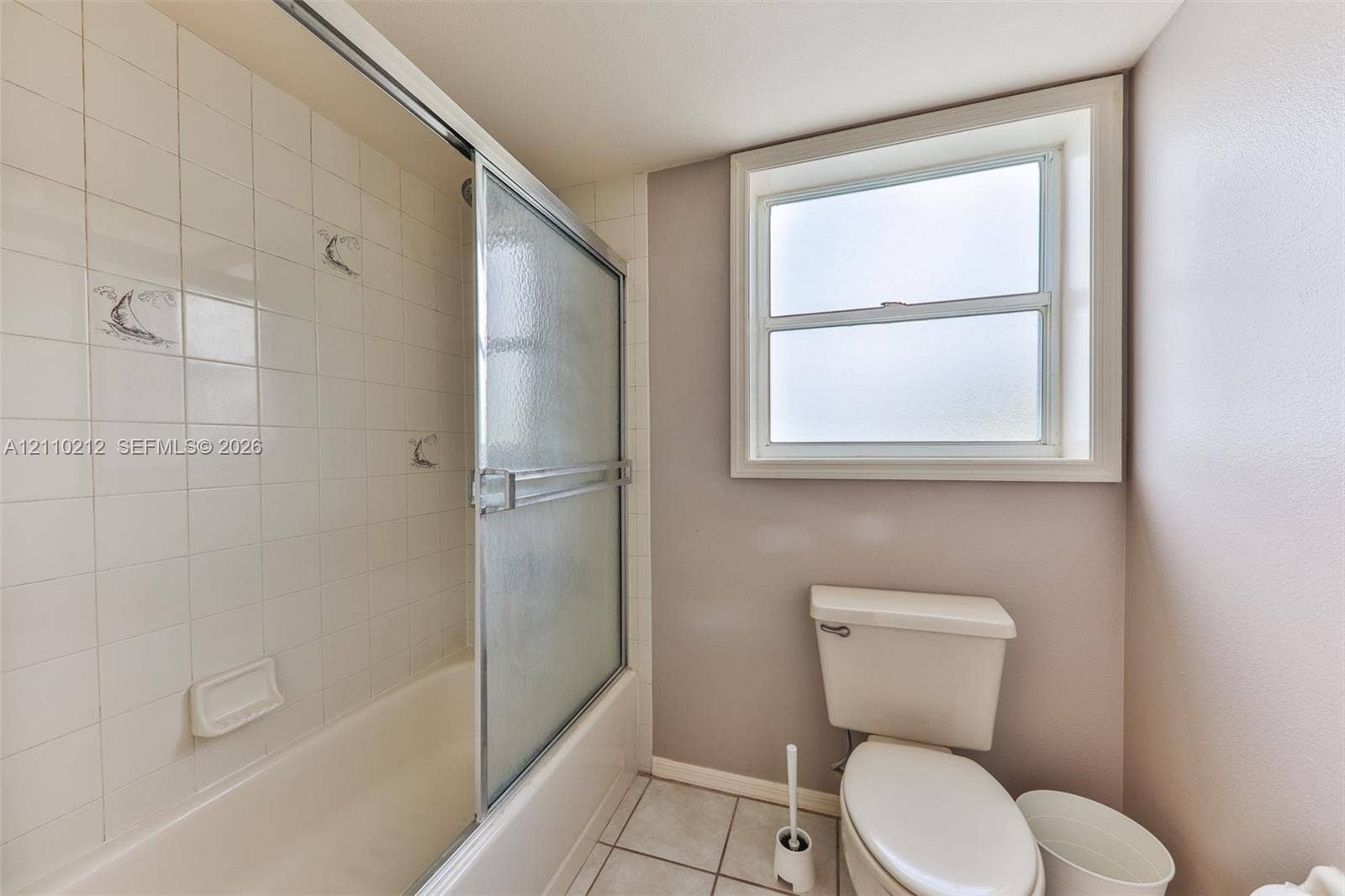 407 SW 37, Cape Coral, FL 33914 Full bathroom featuring a shower-tub combination with sliding glass doors, square-tile wall surround, framed window, and ceramic floor tiling