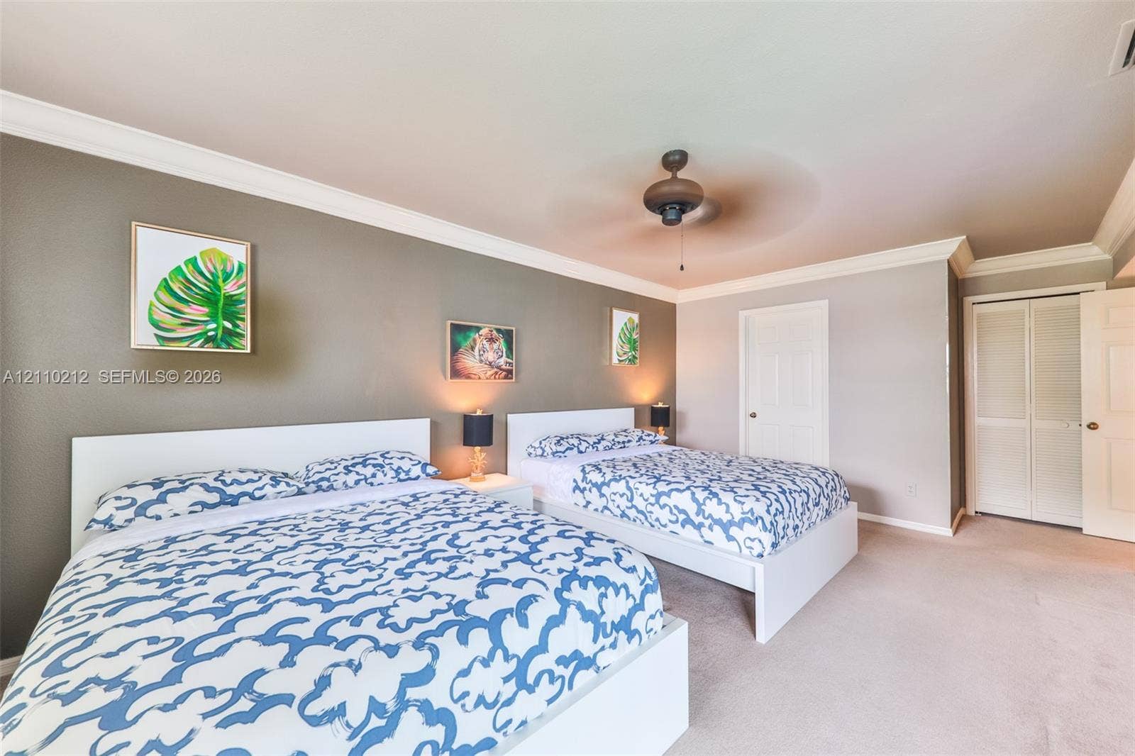 407 SW 37, Cape Coral, FL 33914 Room featuring an accent wall, crown molding, wall-to-wall carpeting, a ceiling fan, and double-door closet storage