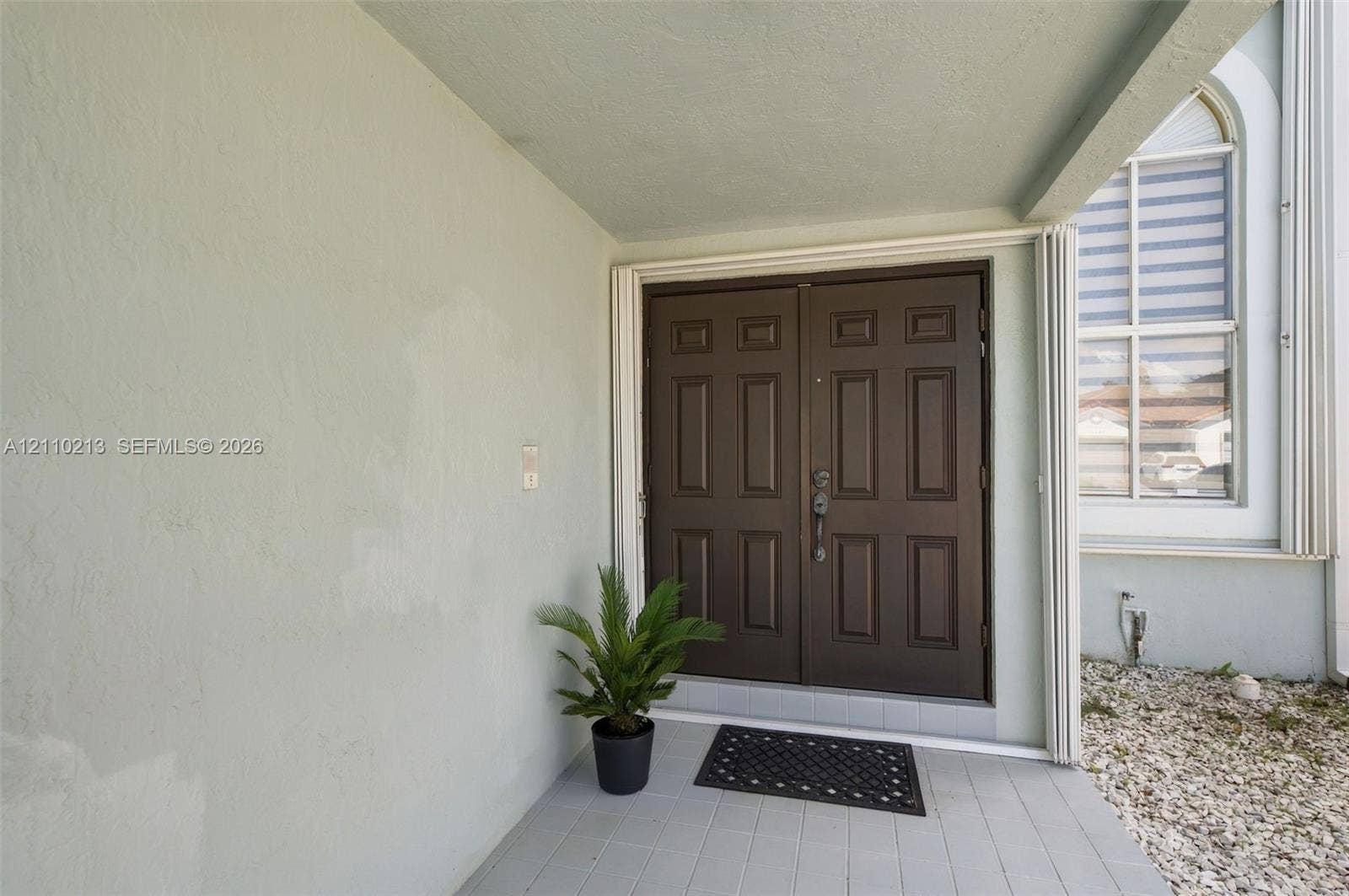 Covered entryway featuring double-door entry, paneled door design, and tiled porch flooring