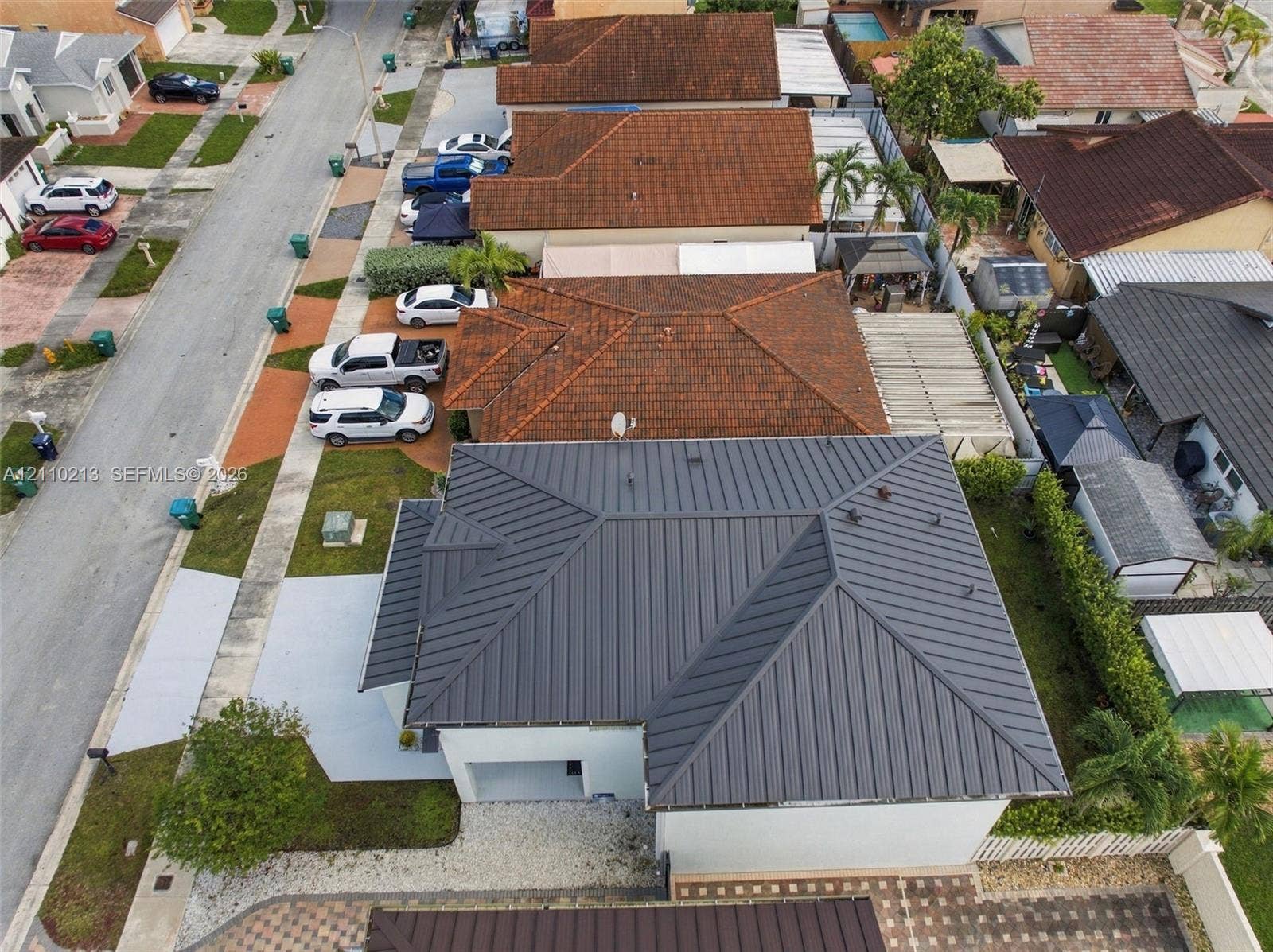 Standing seam metal roof, paved driveway, and side-entry garage
