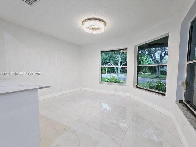 Large-format tile flooring, bay windows, and a modern circular chandelier fixture