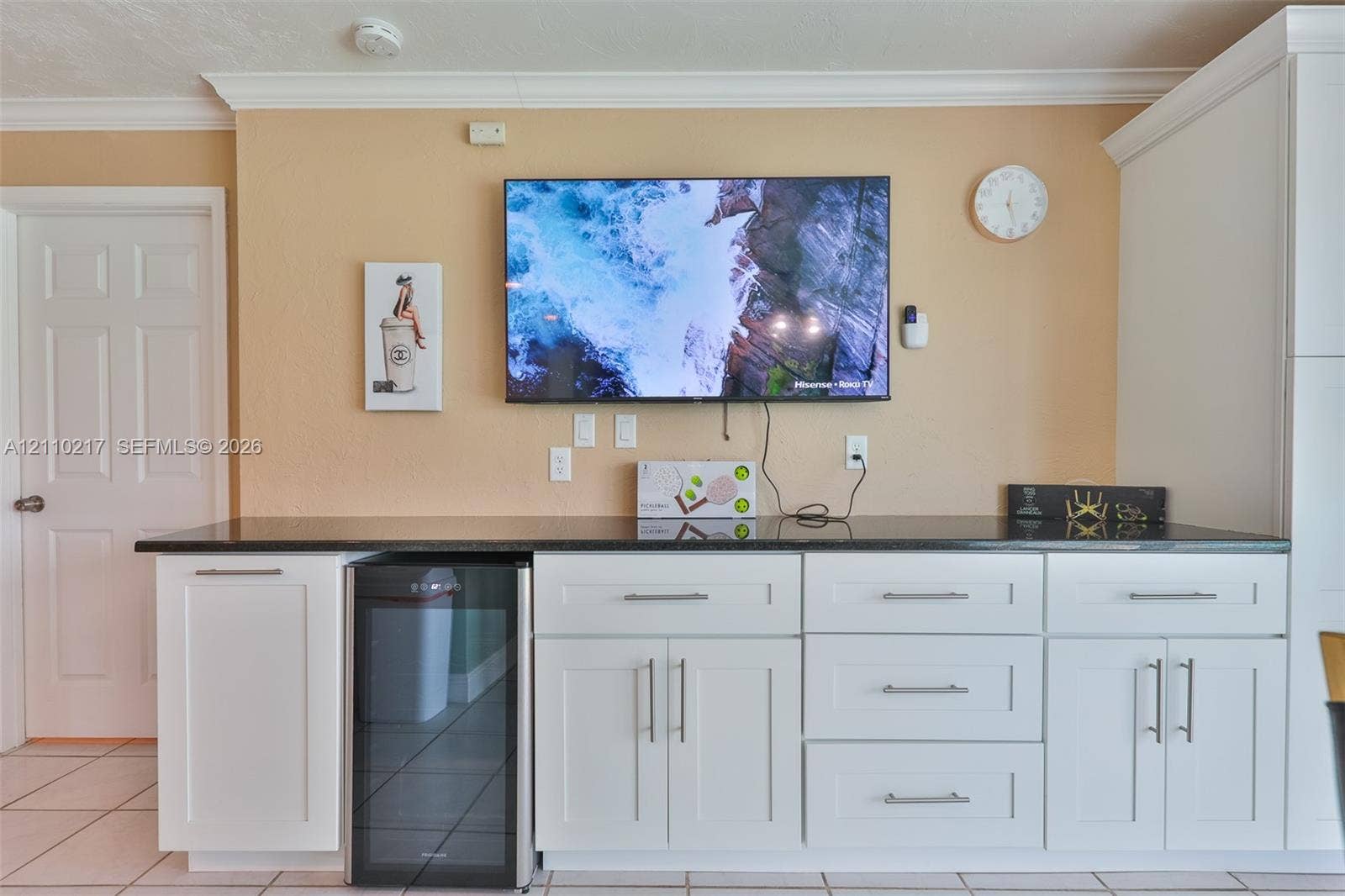 503 SW 17 Street, Cape Coral, FL 33990 Built-in cabinetry featuring white shaker-style doors and drawers, dark stone-finish countertop, brushed nickel hardware, and dedicated beverage refrigerator niche