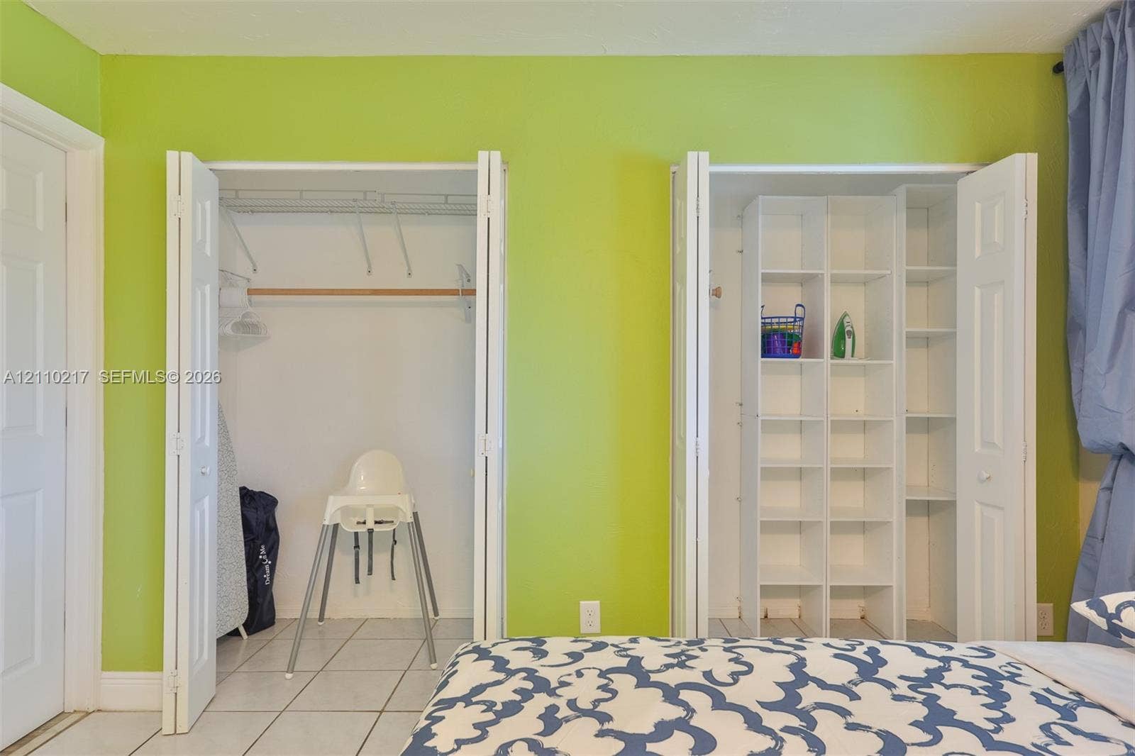 503 SW 17 Street, Cape Coral, FL 33990 Dual closets featuring bi-fold doors, white interior shelving, and overhead rods, finished with tile flooring