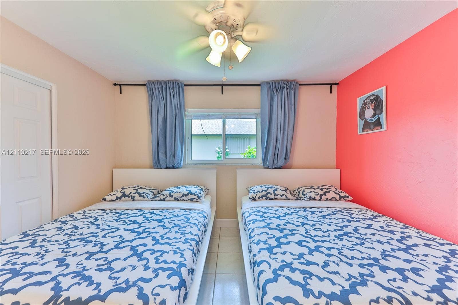 503 SW 17 Street, Cape Coral, FL 33990 Room featuring neutral wall tones, a bold accent wall, ceramic tile flooring, and a ceiling-mounted light fixture with a central fan