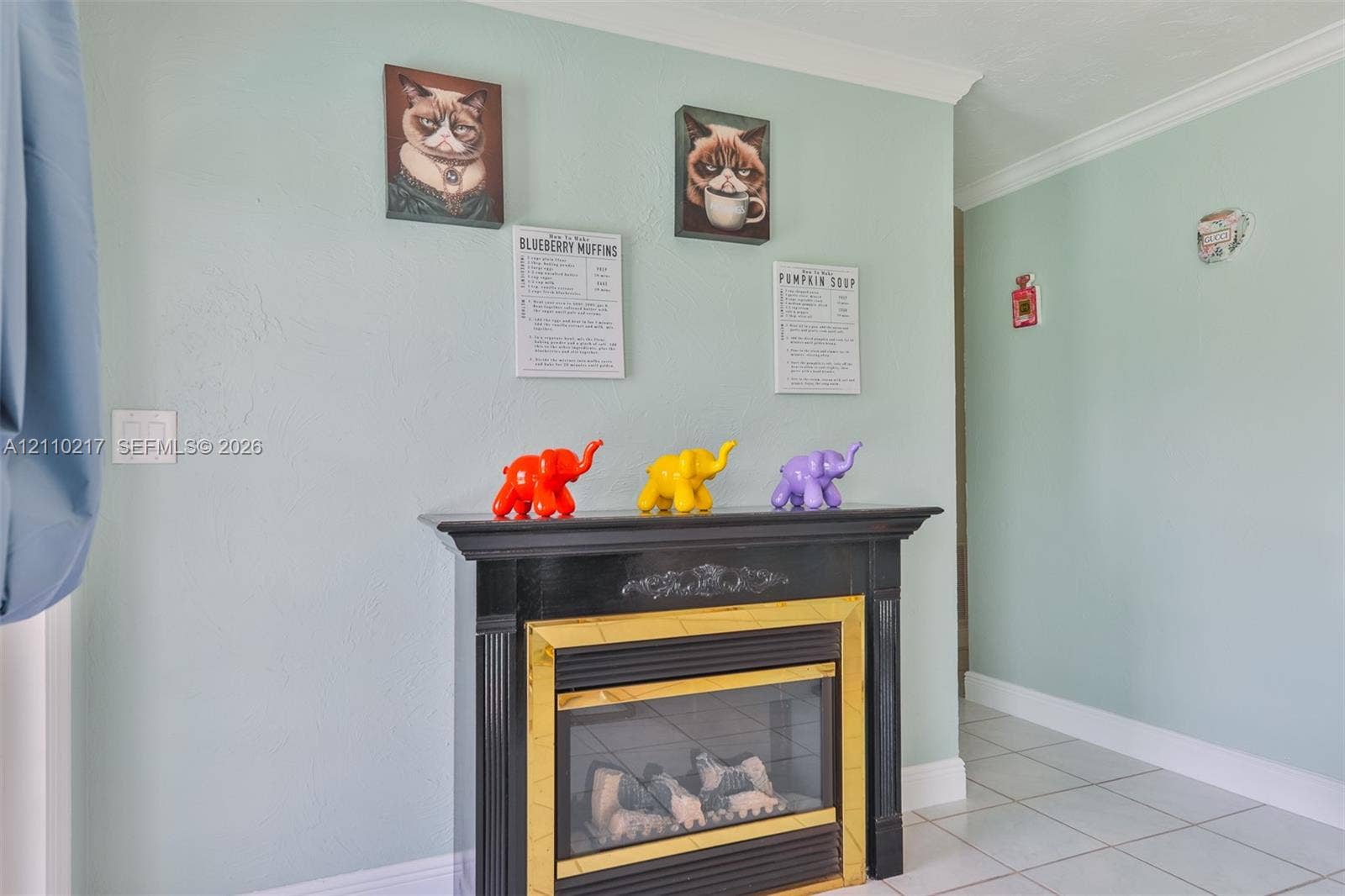 503 SW 17 Street, Cape Coral, FL 33990 Fireplace featuring a black mantel, brass-tone surround, and crown molding