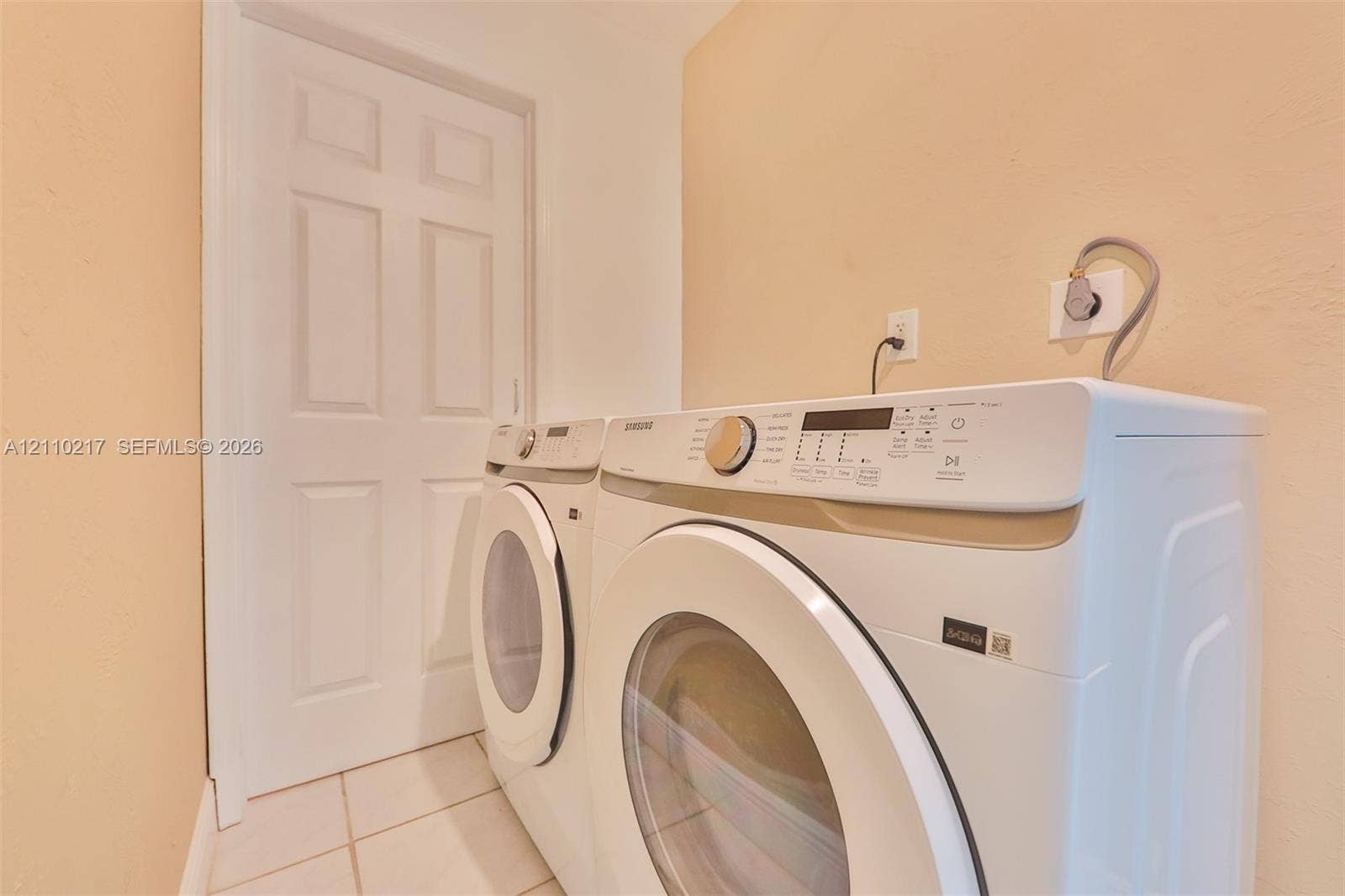 503 SW 17 Street, Cape Coral, FL 33990 Dedicated utility area featuring tile flooring, a solid-core interior door, and hookups for laundry appliances