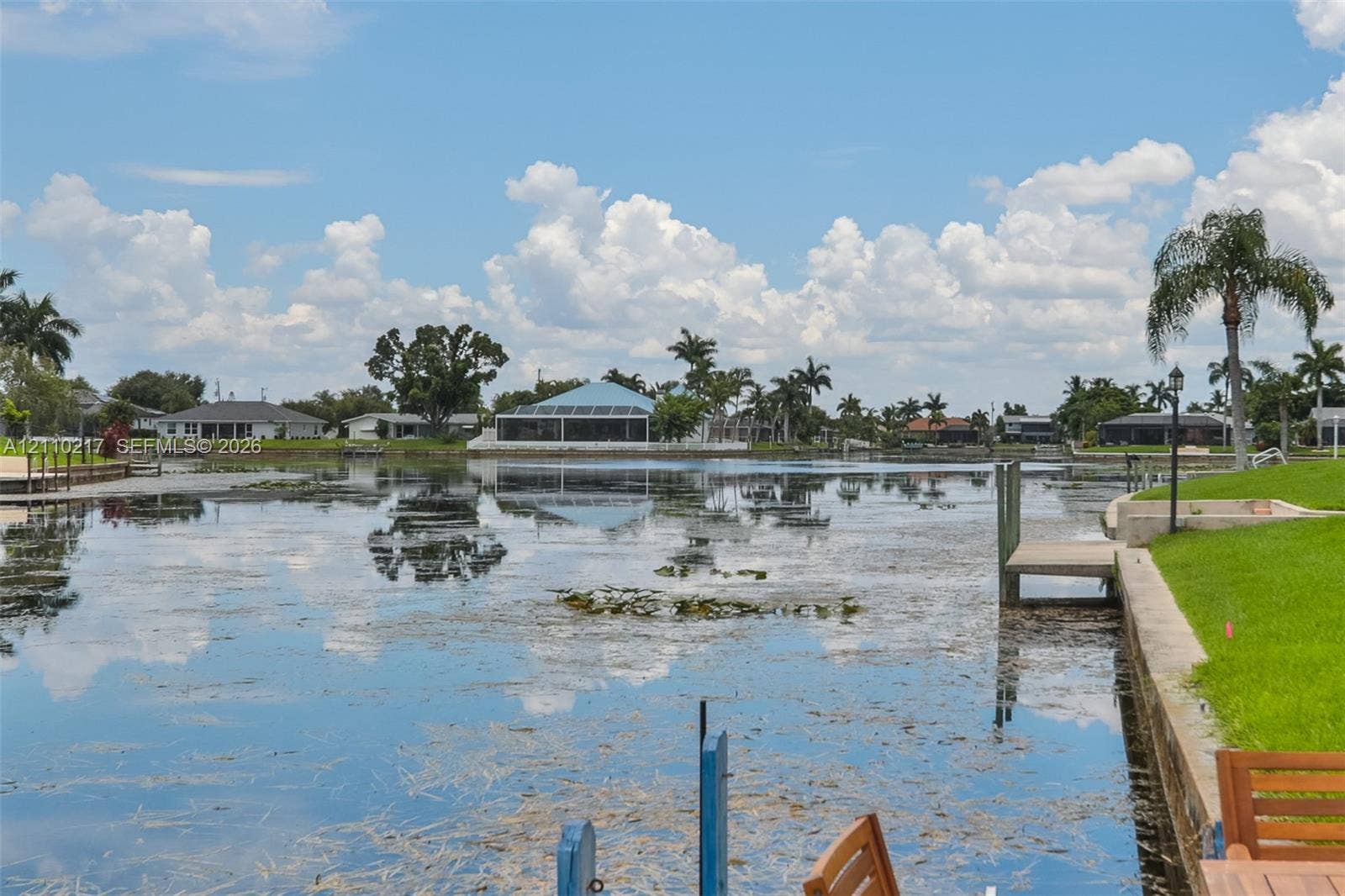503 SW 17 Street, Cape Coral, FL 33990 Waterfront property featuring a concrete seawall, private dock, and manicured lawn