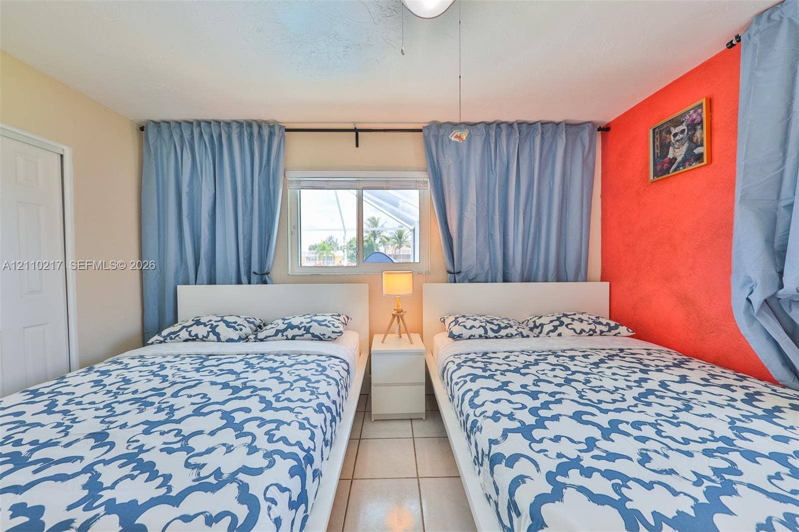 503 SW 17 Street, Cape Coral, FL 33990 Room featuring white tiled flooring, a single-panel interior door, and a sliding window with a horizontal metal frame