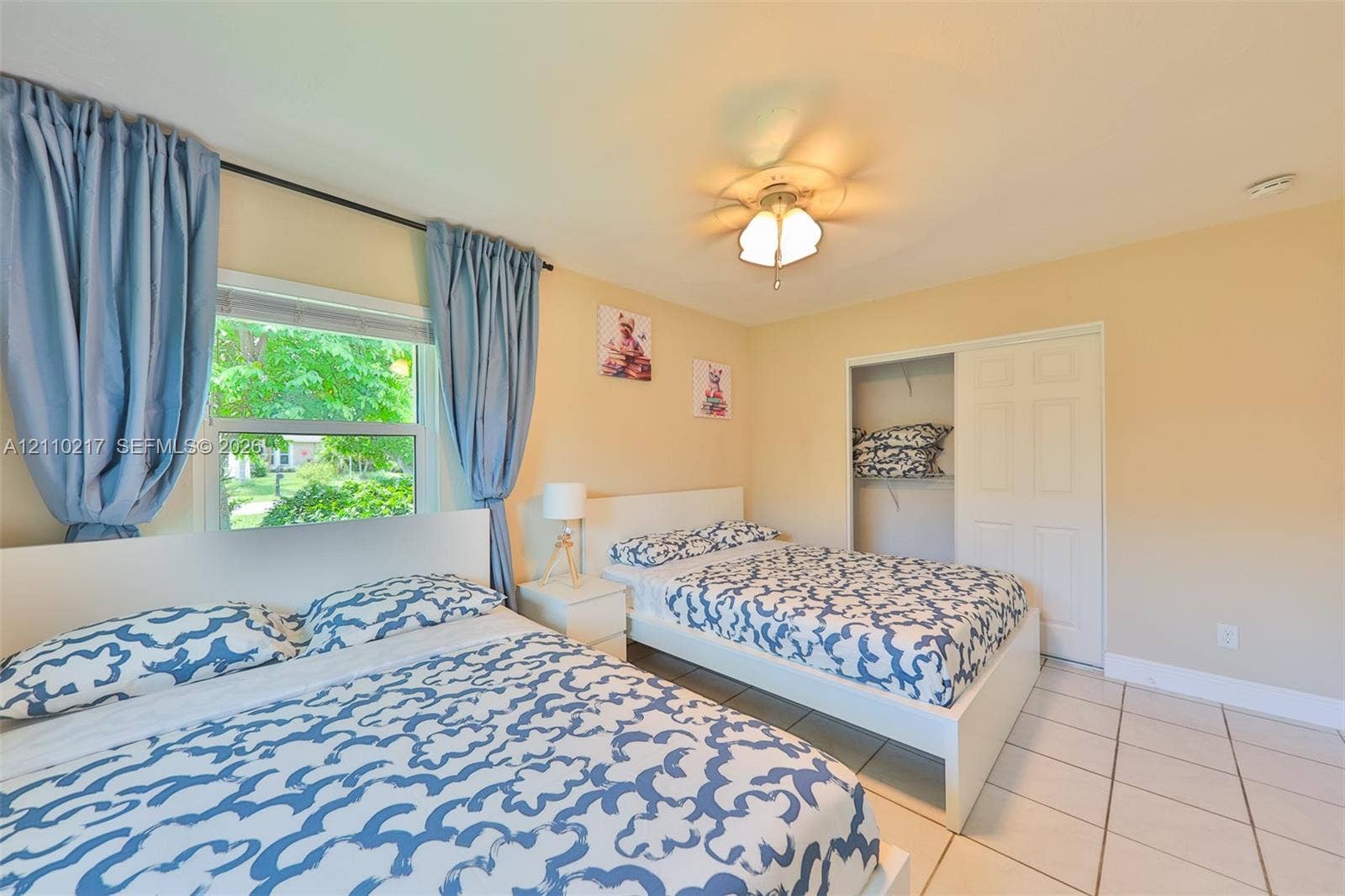 503 SW 17 Street, Cape Coral, FL 33990 Room featuring tile flooring, a window providing natural light, a ceiling-mounted light fixture, and a built-in sliding-door closet