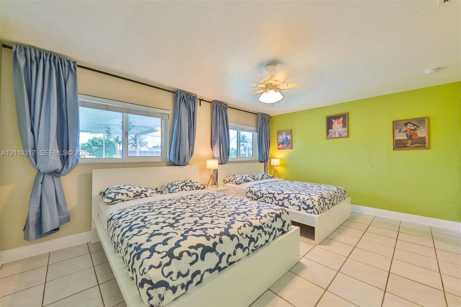 503 SW 17 Street, Cape Coral, FL 33990 Spacious interior featuring large-format tile flooring, dual sliding windows with natural lighting, and a white ceiling fan with integrated light fixture