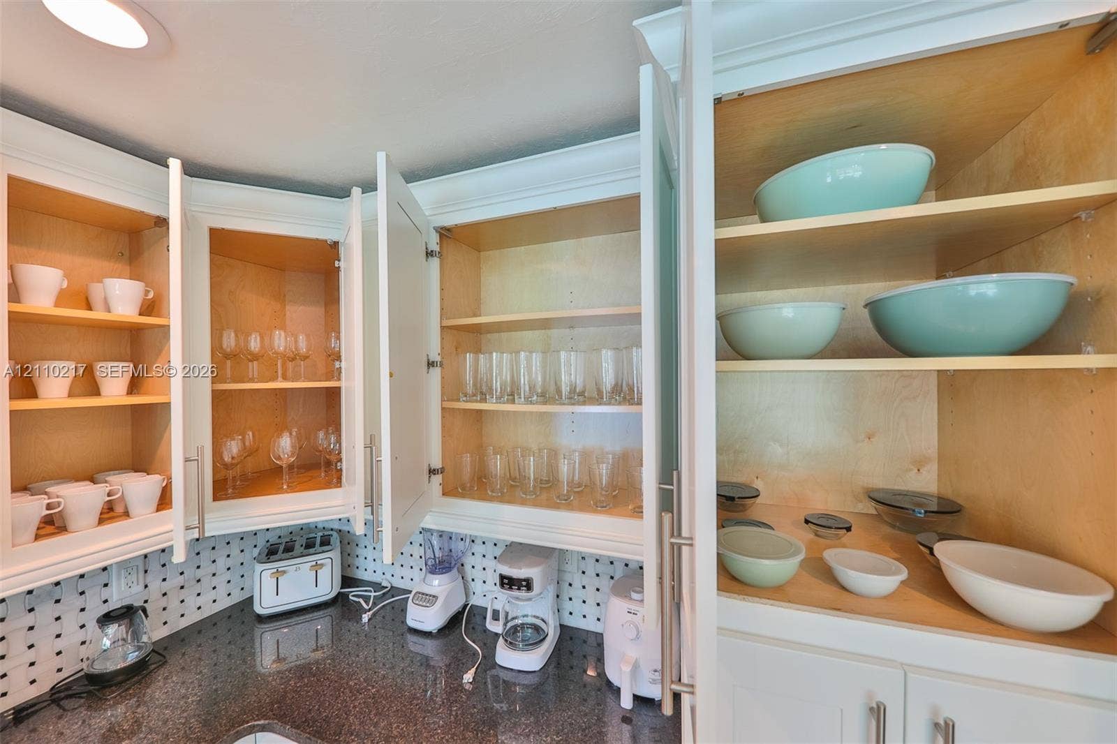 503 SW 17 Street, Cape Coral, FL 33990 White shaker-style cabinetry with interior shelving, polished stone countertops, and integrated pegboard wall backing