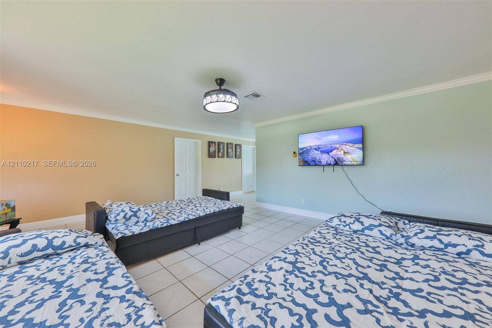503 SW 17 Street, Cape Coral, FL 33990 Spacious interior featuring neutral tile flooring, crown molding, and a contemporary drum-style ceiling light fixture