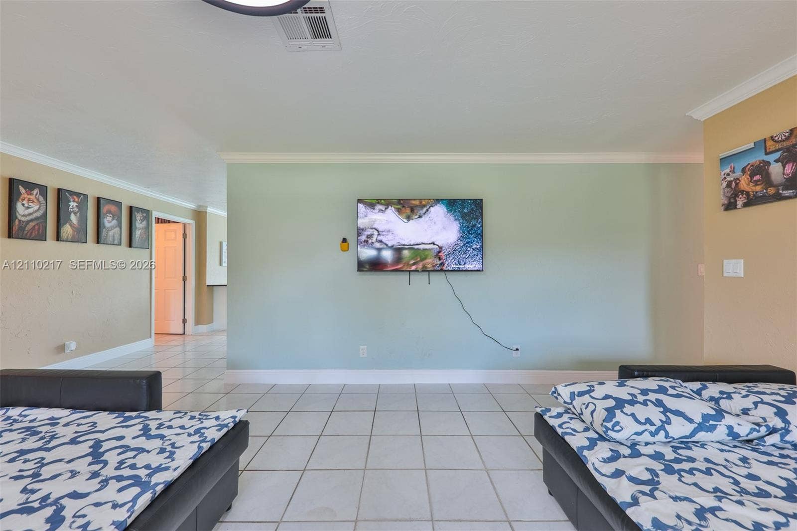 503 SW 17 Street, Cape Coral, FL 33990 Interior space featuring white tiled flooring, crown molding, and an accent wall