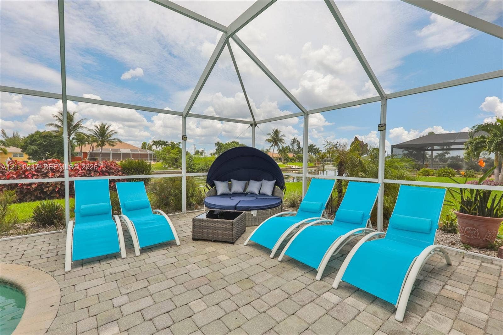 503 SW 17 Street, Cape Coral, FL 33990 Screened lanai featuring paver flooring, a pool edge, and surrounding water frontage
