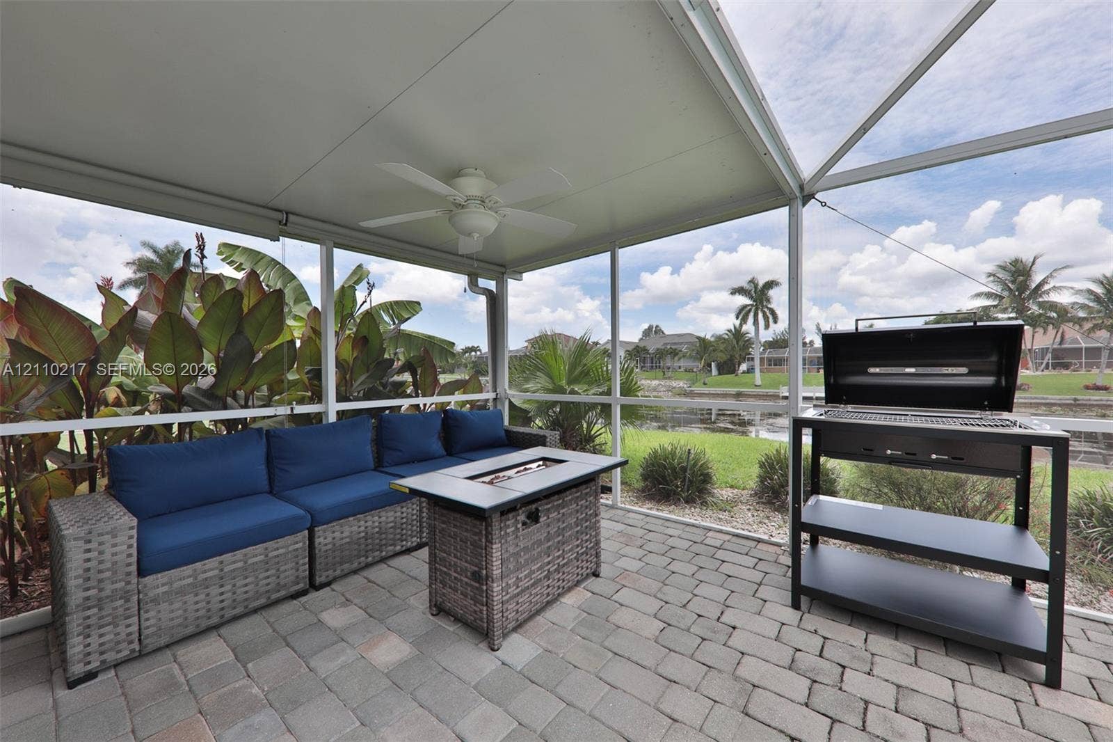 503 SW 17 Street, Cape Coral, FL 33990 Screened-in lanai featuring a paver floor, overhead ceiling fan, and metal grill station